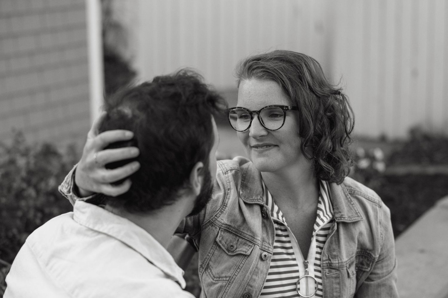 A couple shares a tender moment while sitting close together.