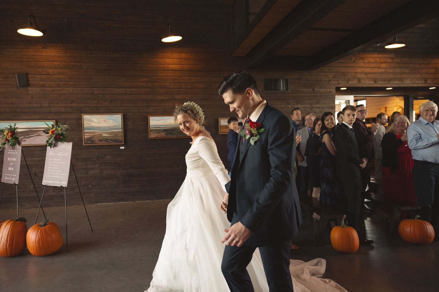 Indoor wedding reception venue with dark wood walls and pumpkin decorations.