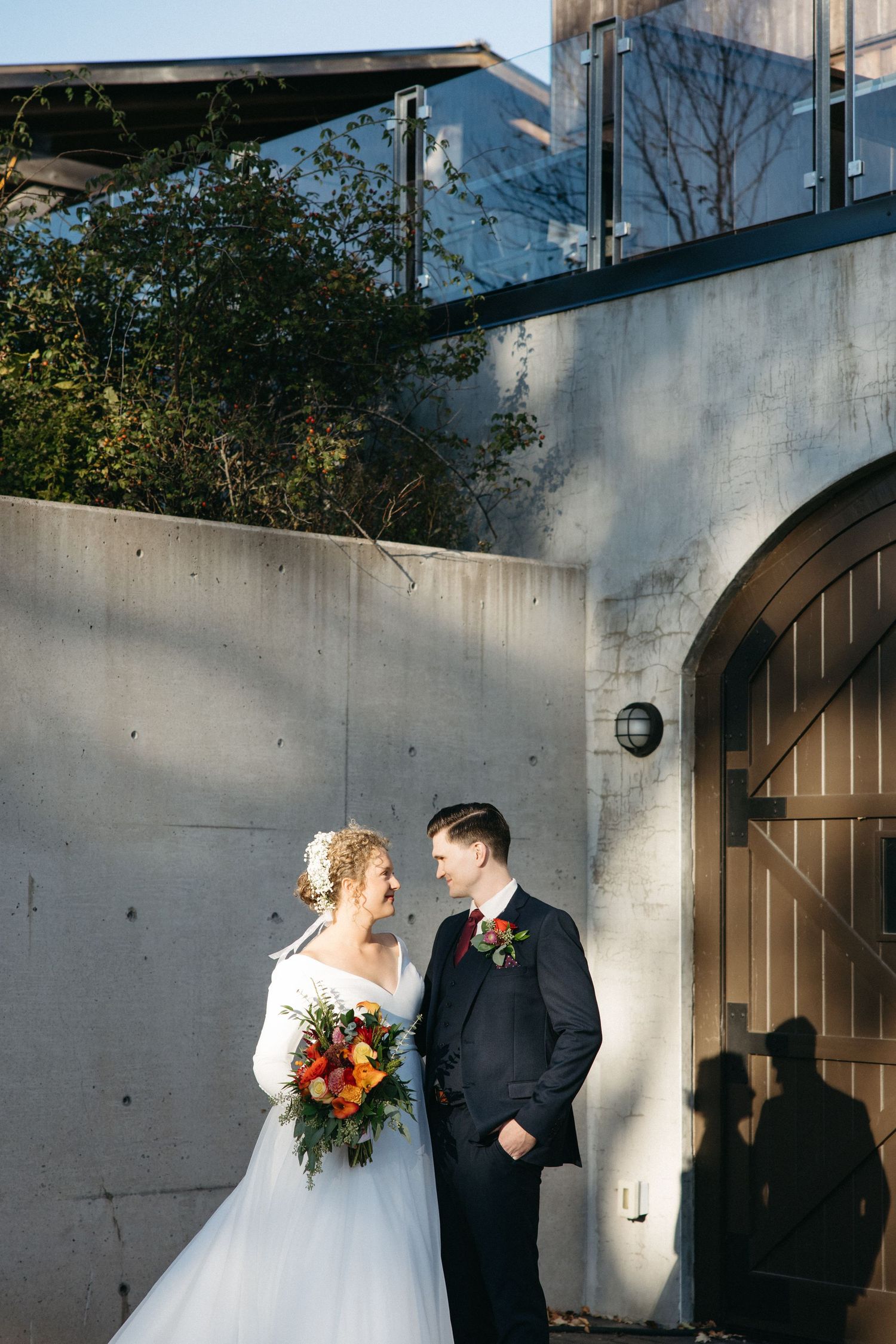 Modern architectural wedding portraits with concrete walls and dramatic lighting.