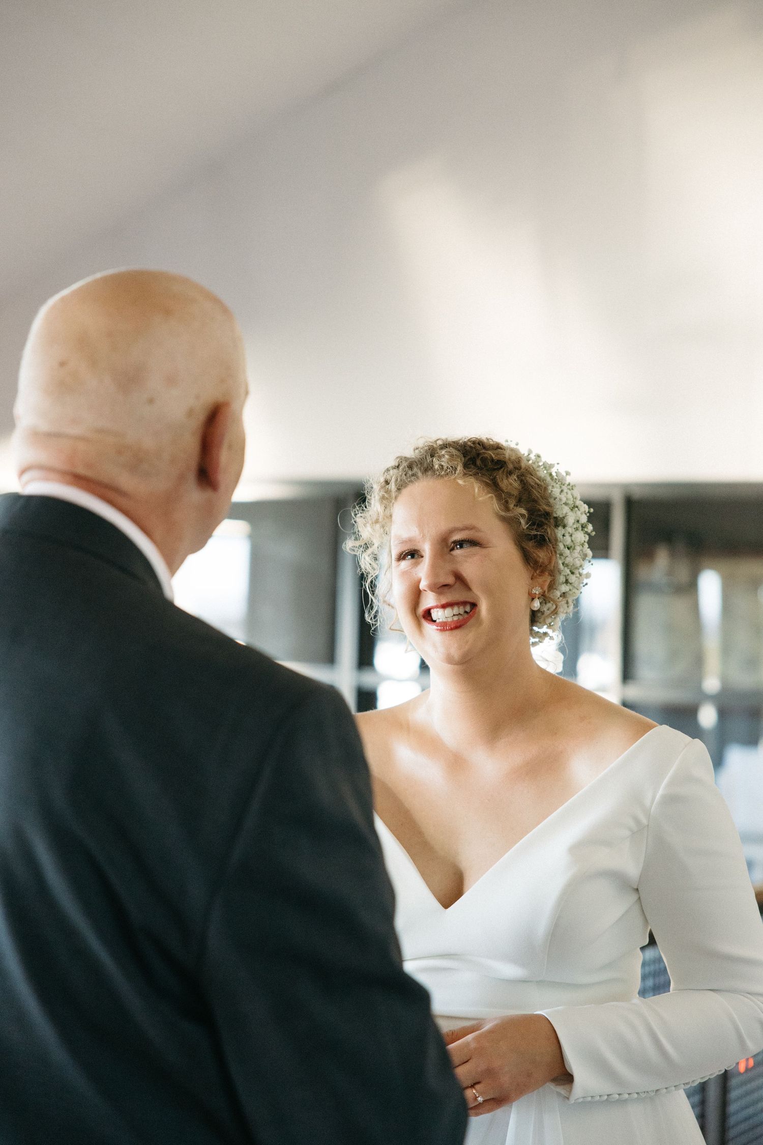 A bride in a white dress shares a joyful moment during a wedding celebration.