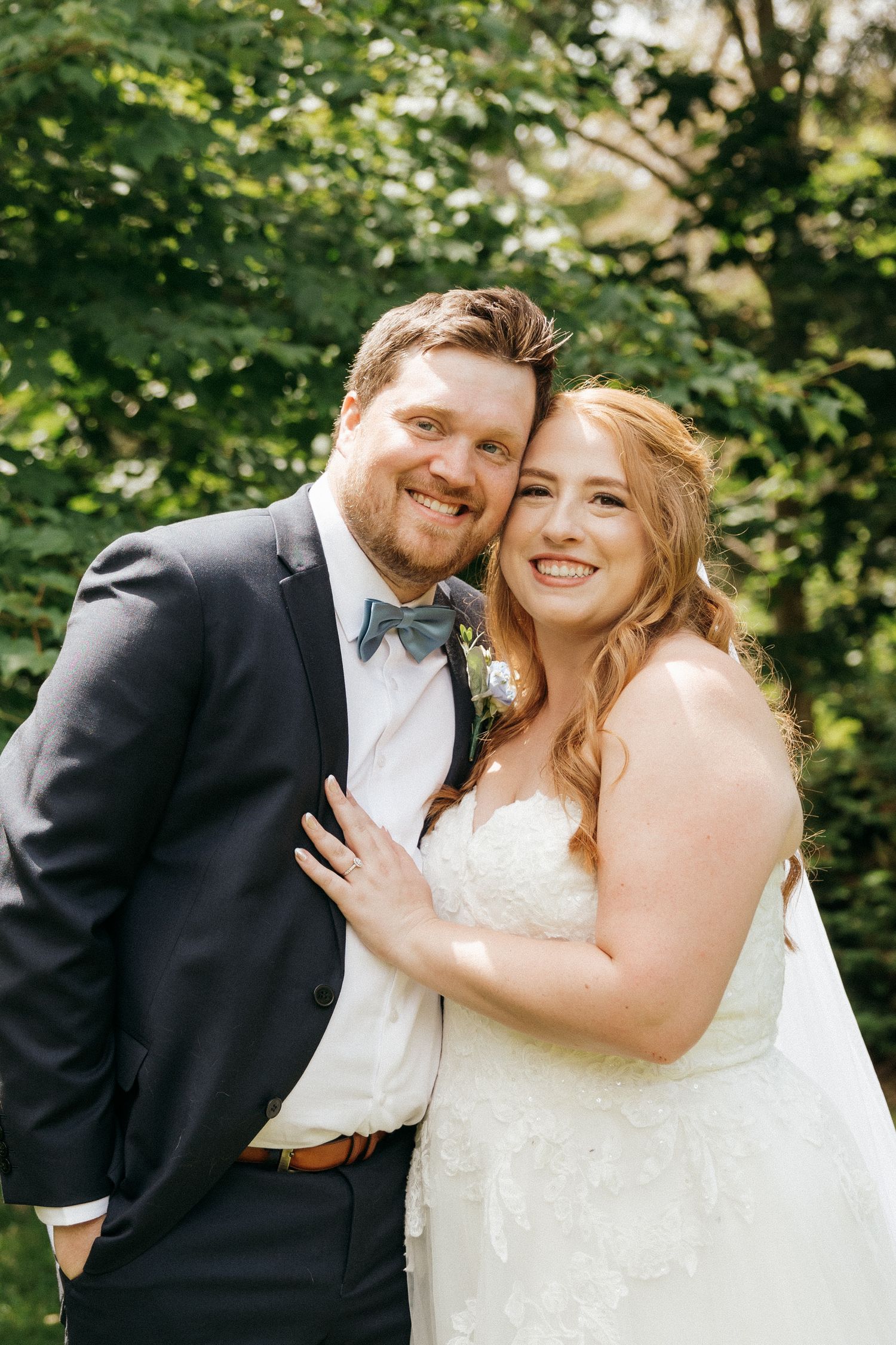 A couple shares joyful candid moments together during their outdoor wedding photo session.