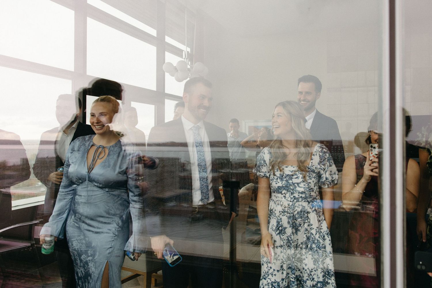 People gather in a modern space with large windows and natural lighting.