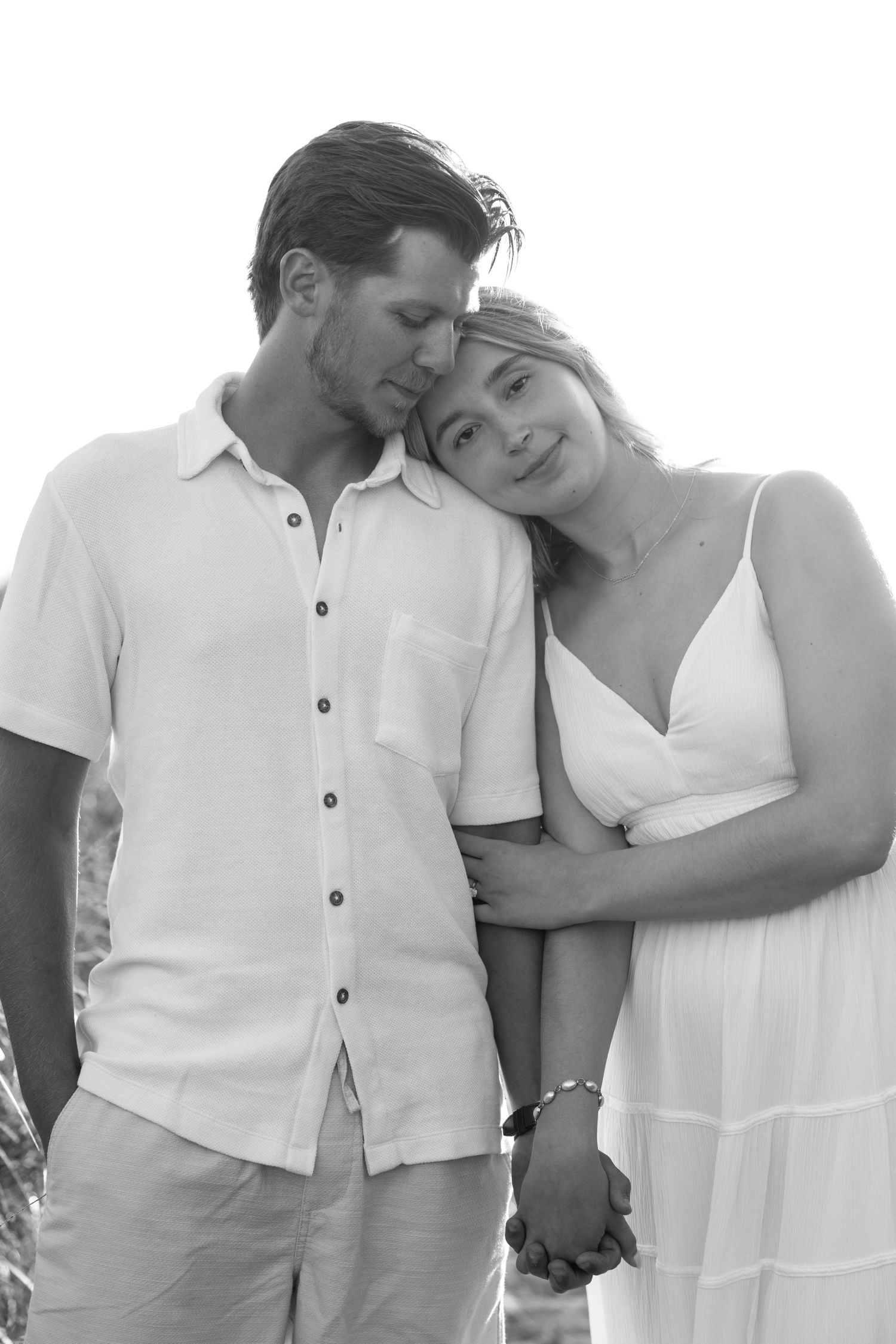 Black and white portrait of couple embracing tenderly outdoors.