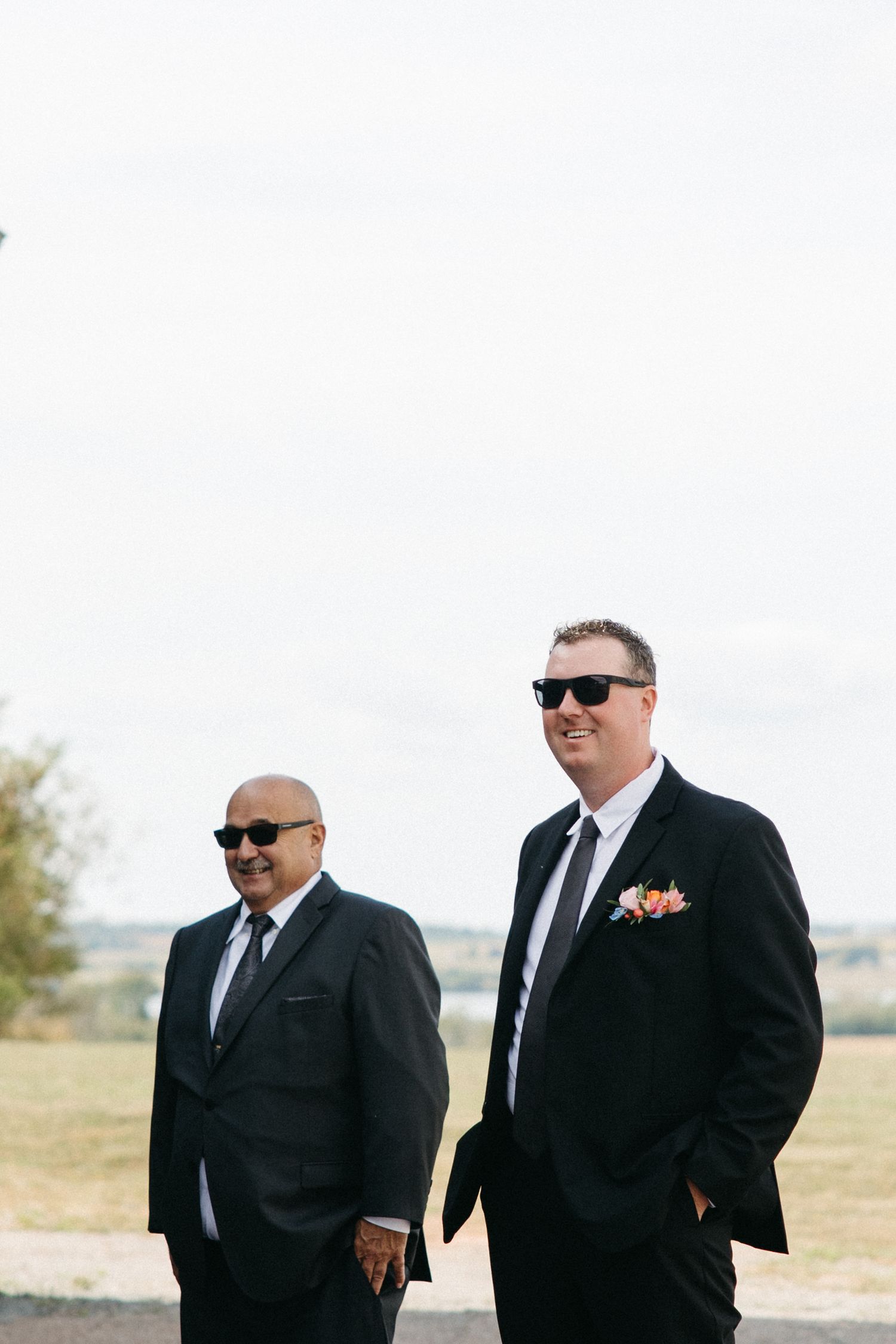 Men in black suits and sunglasses standing outdoors.
