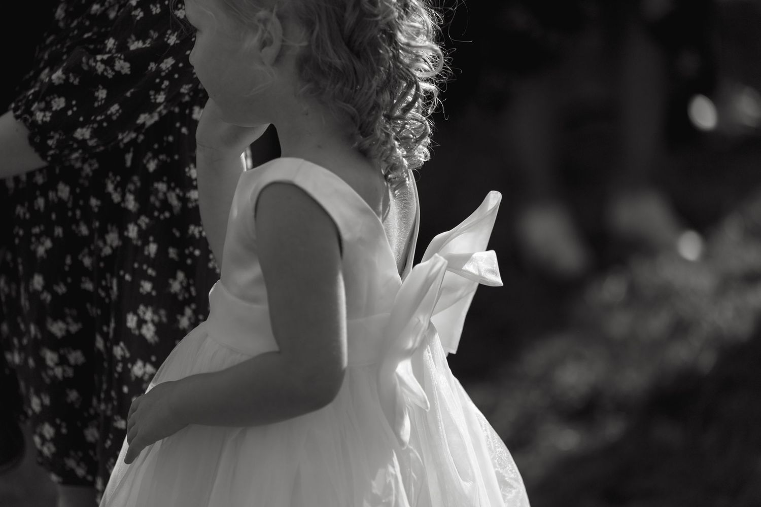 Bridesmaids in matching dresses share candid moments at outdoor wedding.
