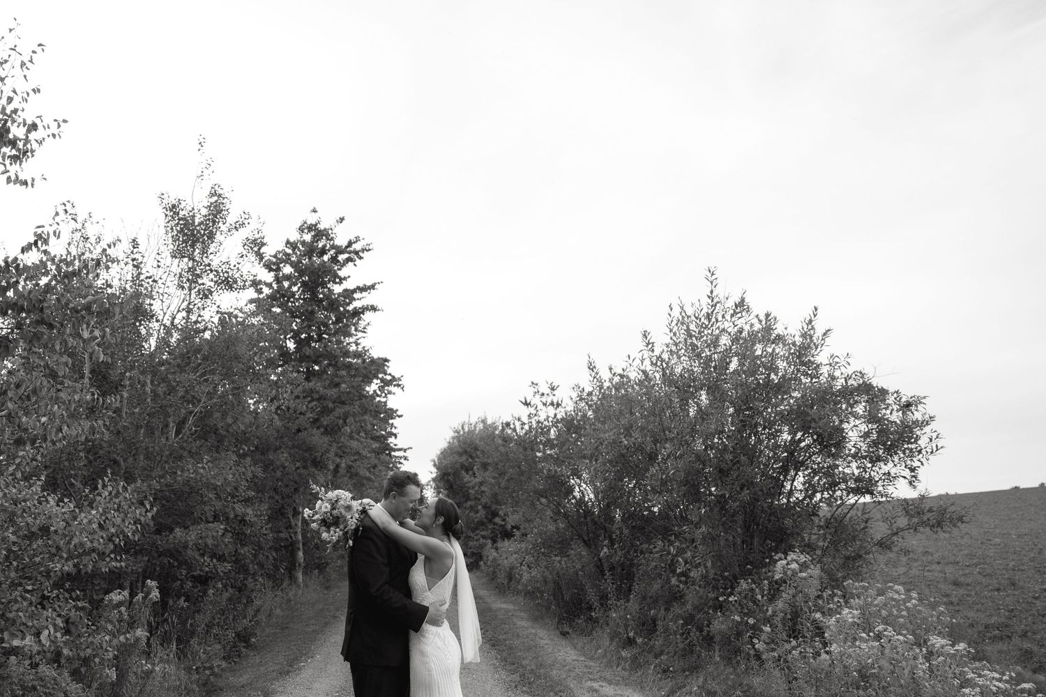 Black and white wedding photography in an orchard setting.