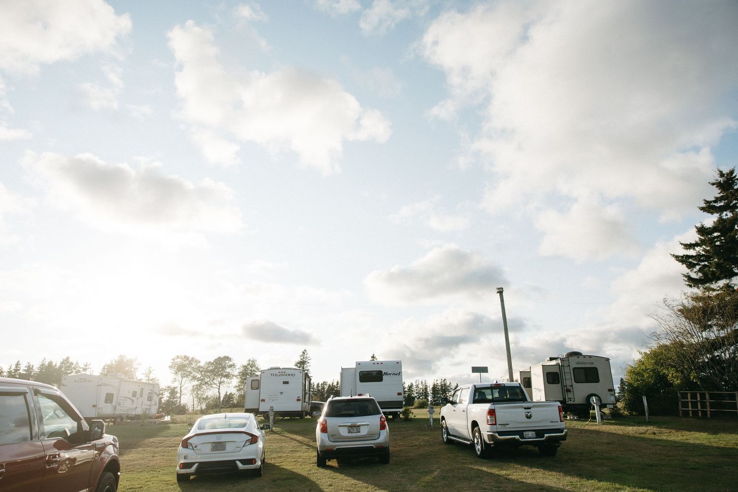 RVs and campers parked on a hilltop against a cloudy sky.