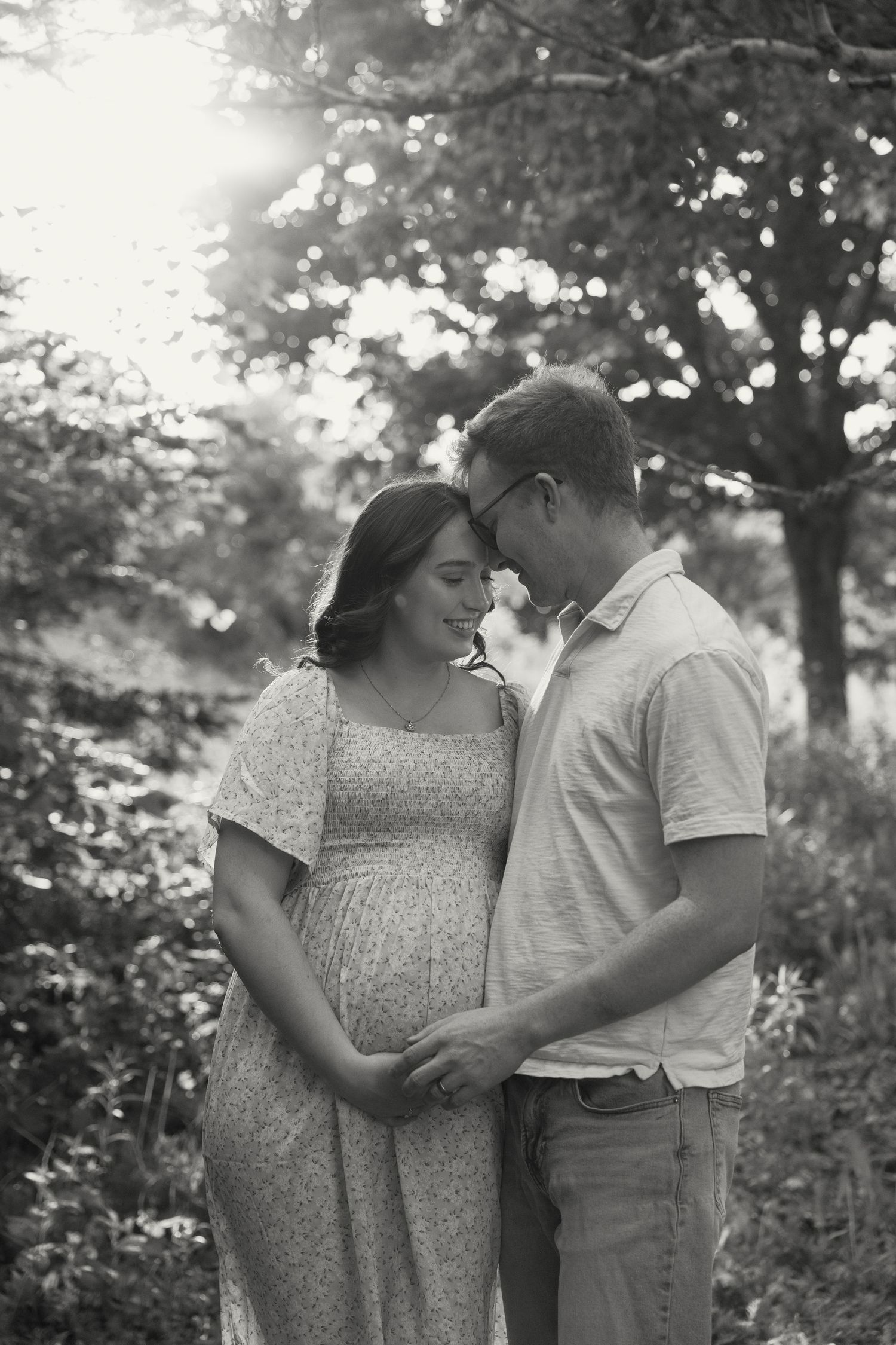Black and white intimate portrait of a couple sharing a tender moment in nature.