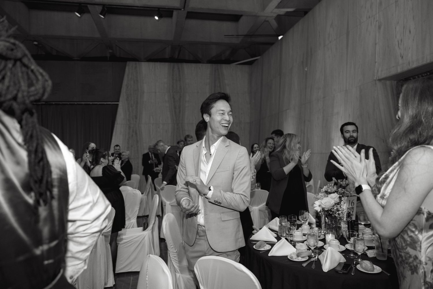 Wedding guests dancing and celebrating at an indoor reception venue.