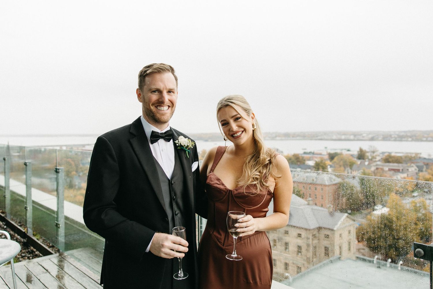 Guests enjoying drinks and conversation with a cityscape view in the background.