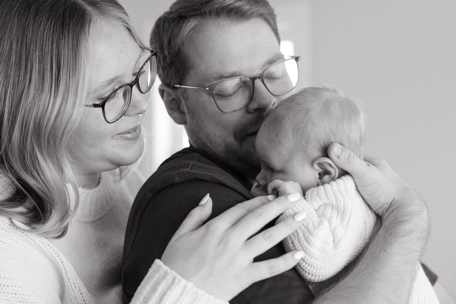 Two people embrace in an intimate black and white portrait.