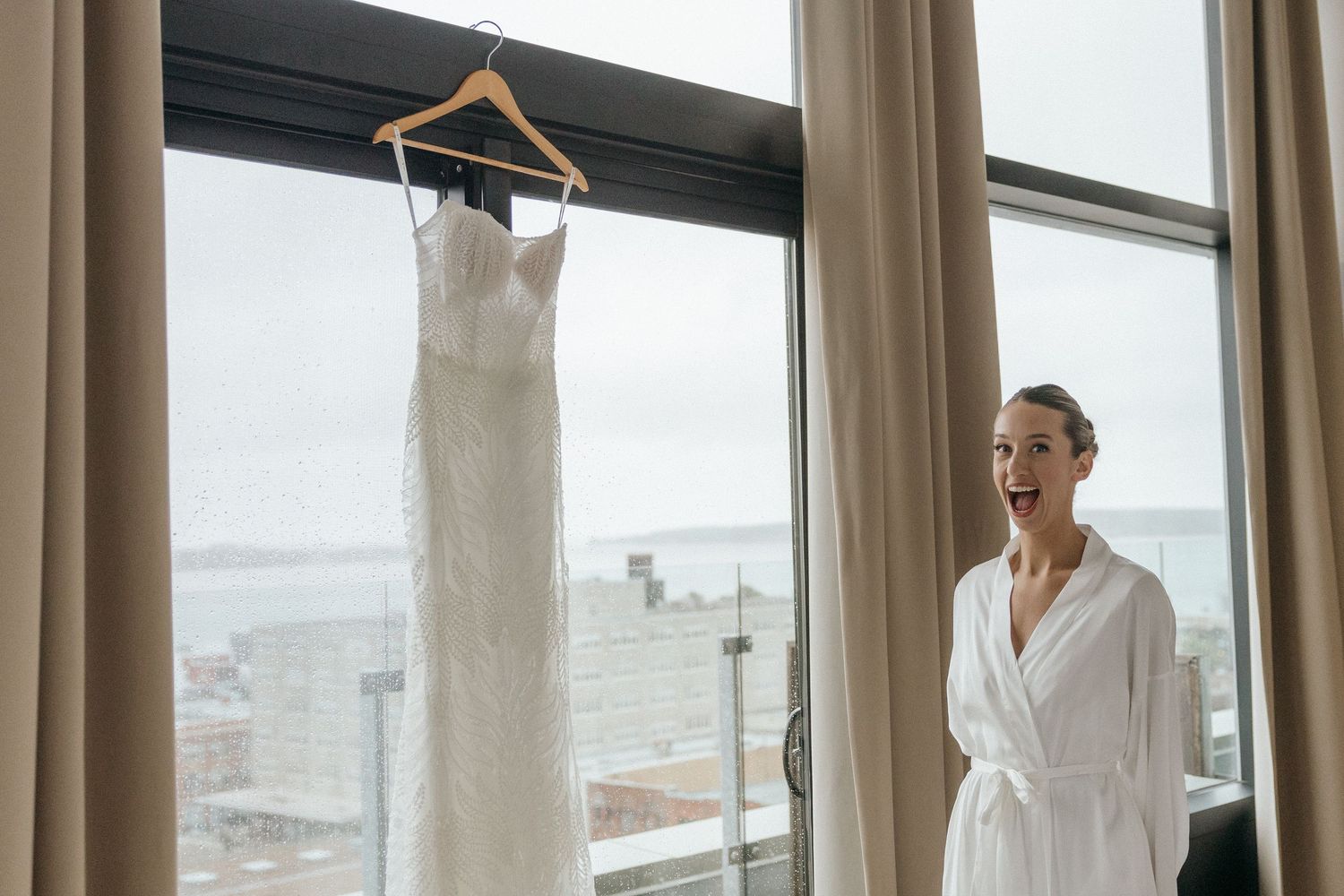 Wedding dresses hanging in sunlit window display.