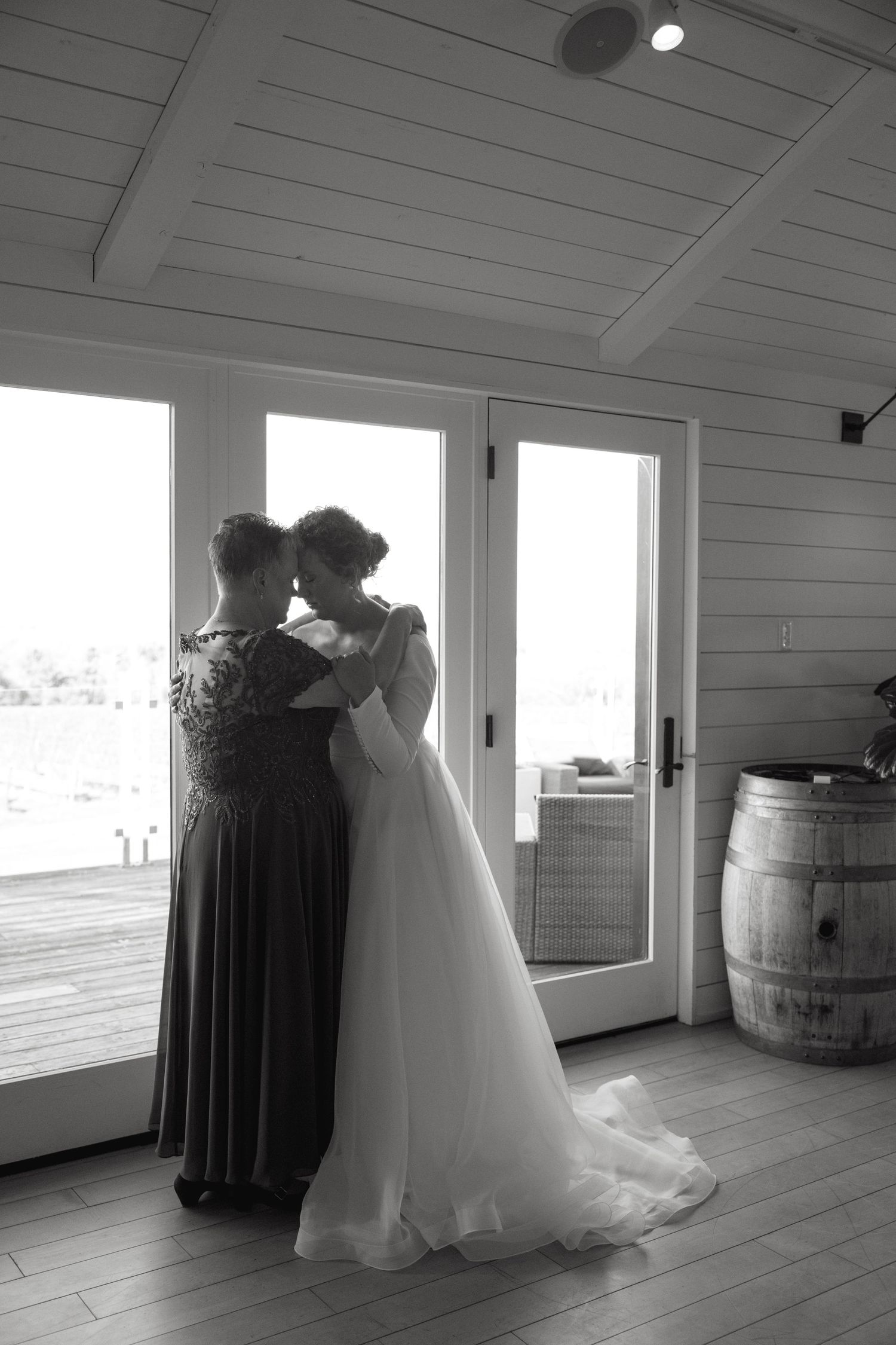 Black and white wedding photo sequence showing a romantic dance between figures in a rustic venue with wooden walls.