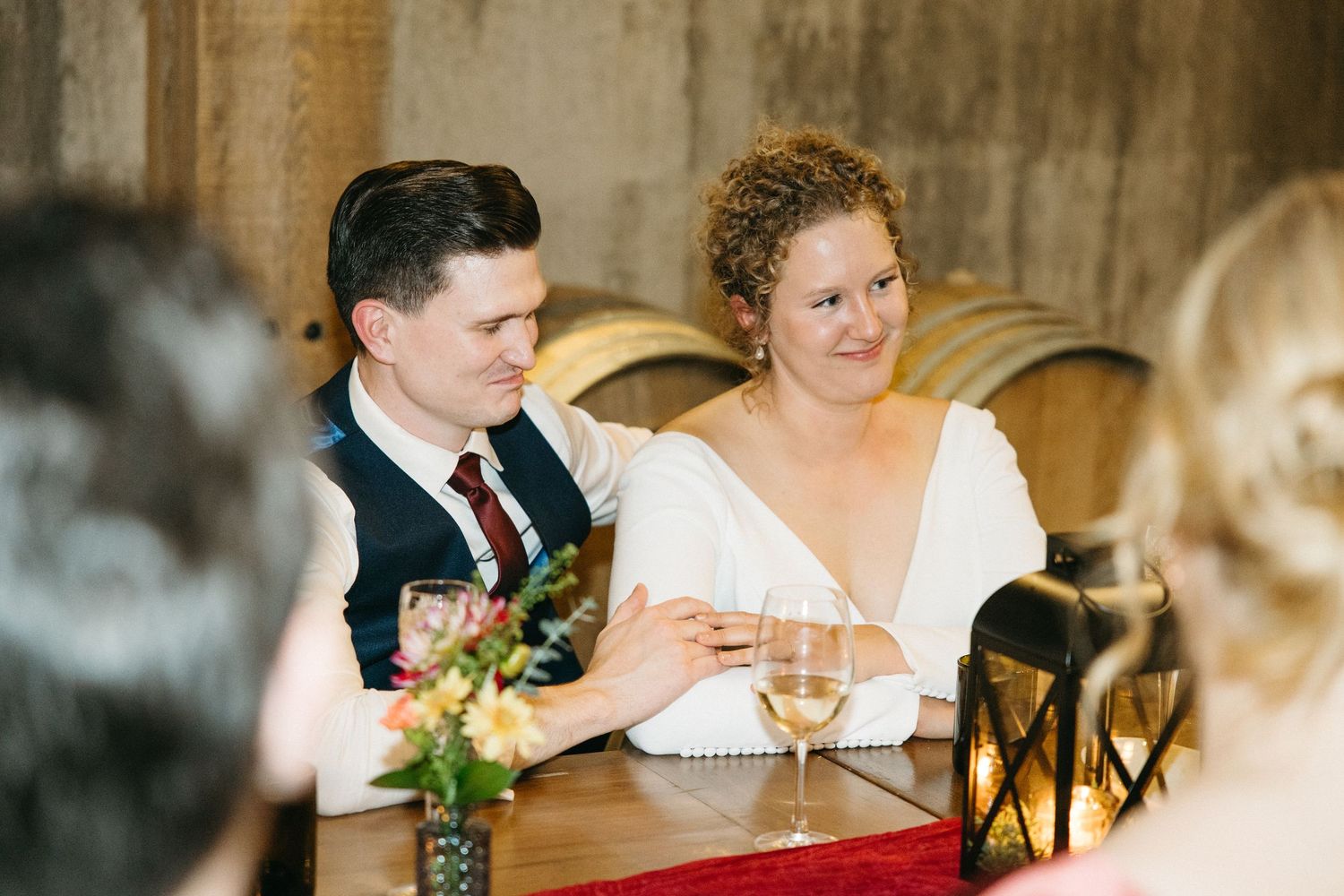 Rustic wedding reception setting with wooden walls and candlelit table decor.