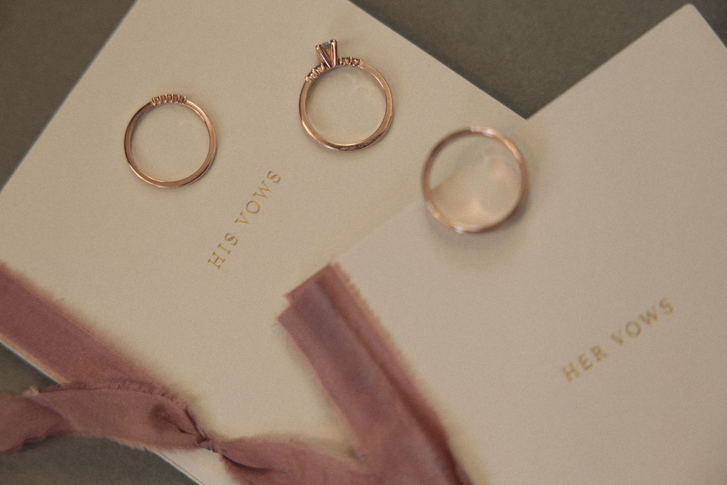 Gold wedding rings arranged on cream colored paper.