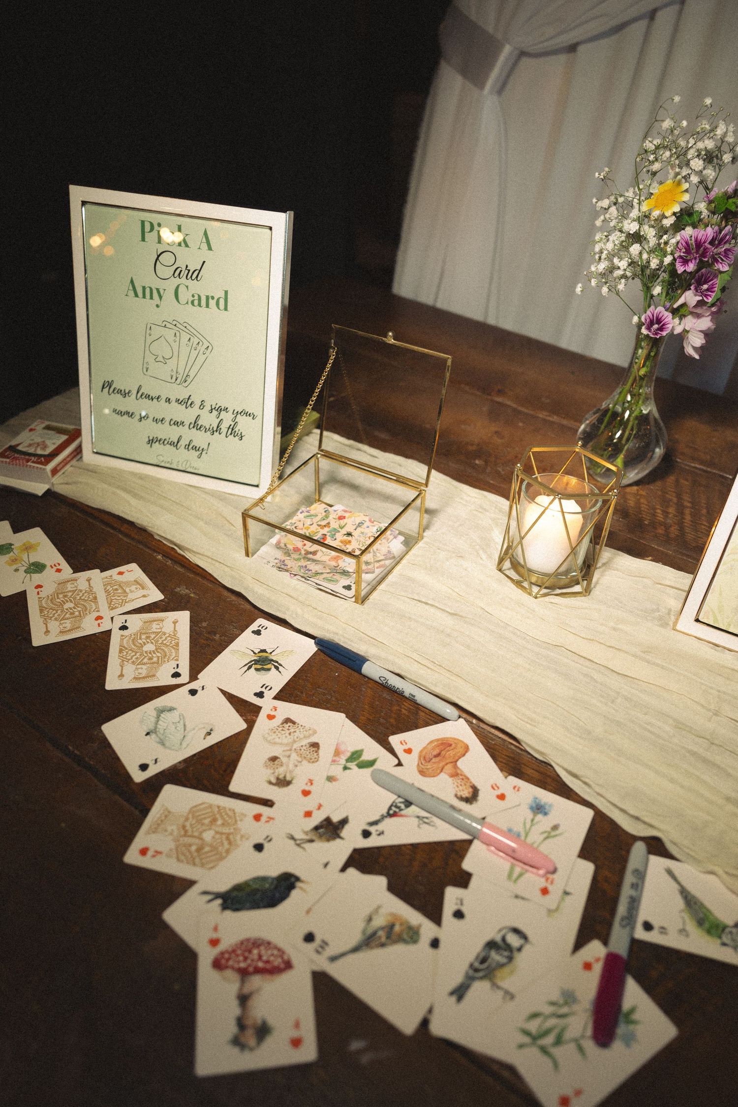 Wedding guest book cards and messages displayed on a rustic wooden table with decorative holders.