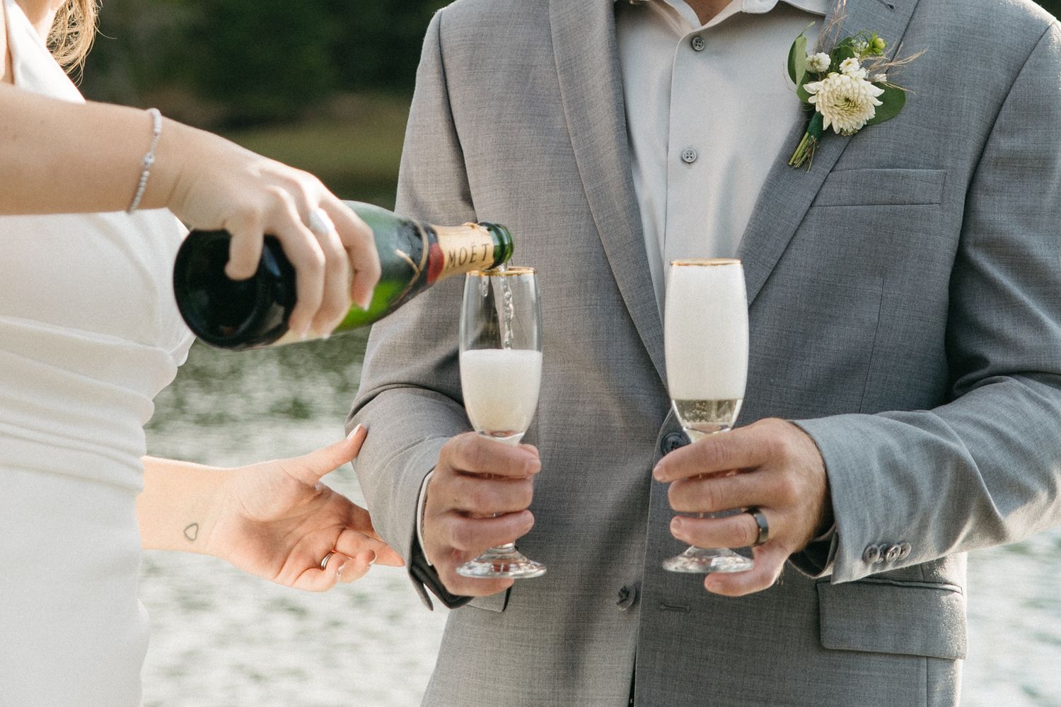 Wedding party holding champagne glasses during outdoor celebration.