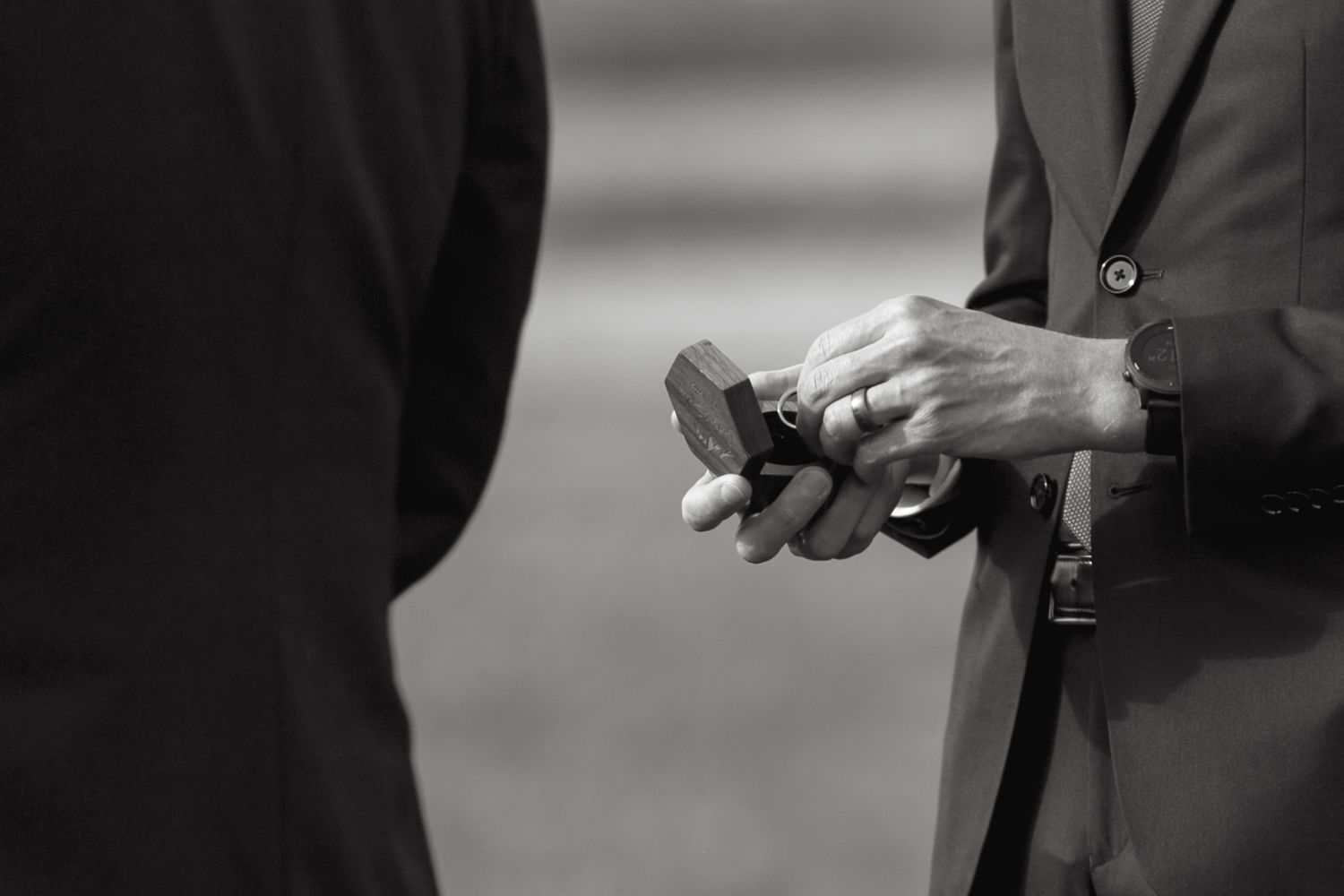 Black and white detail shot of wedding ring ceremony moment.