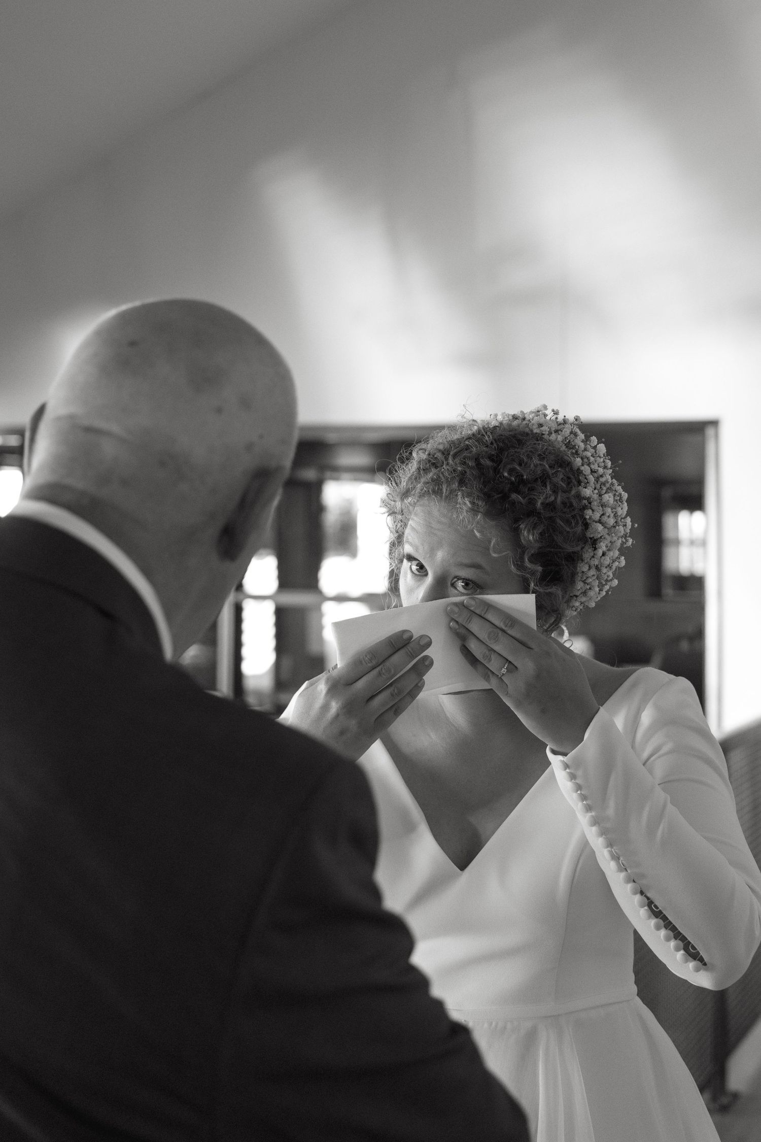 A touching black and white moment during a wedding ceremony showing an emotional exchange.