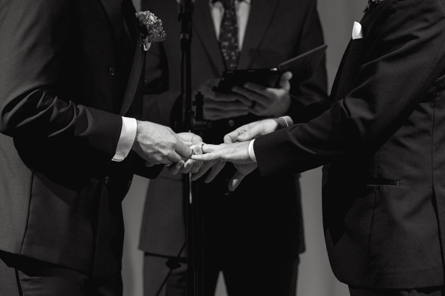 Close-up of hands exchanging items during a formal ceremony.