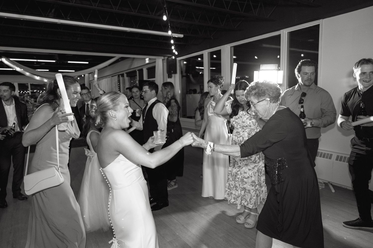 Wedding reception dance floor filled with celebrating guests in formal attire.