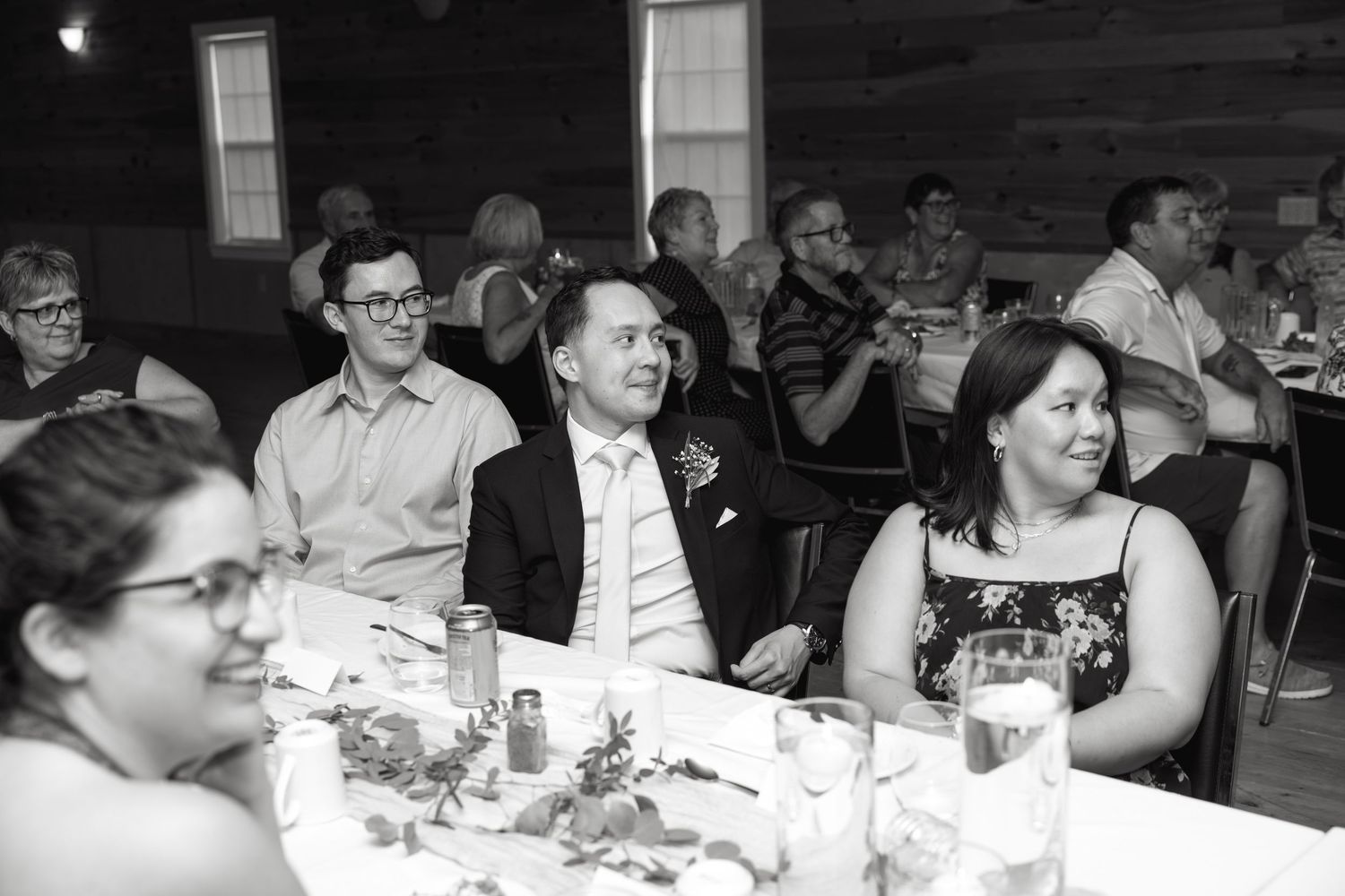 Wedding reception guests seated at tables enjoying dinner and conversation.