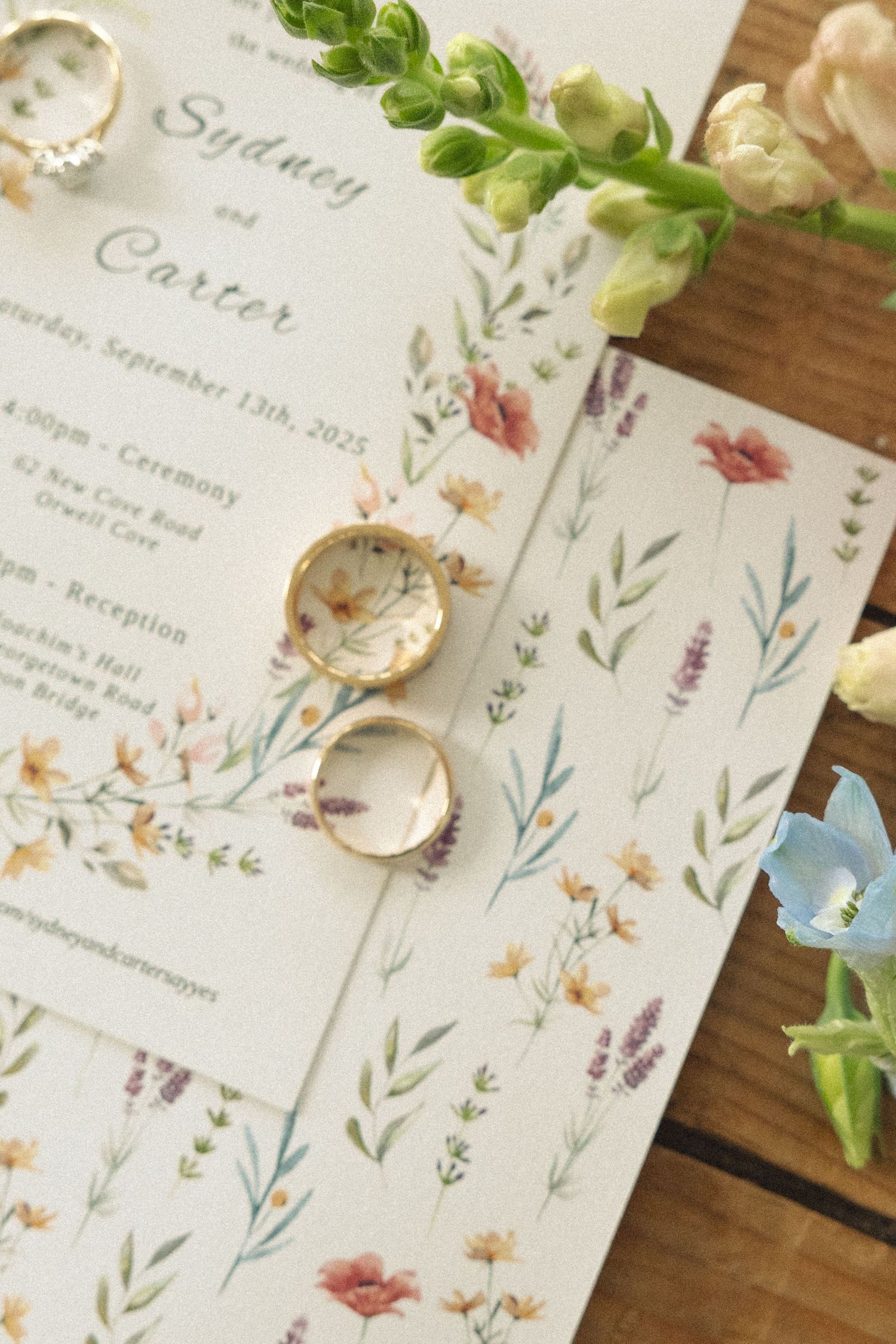 Elegant wedding invitations with delicate watercolor floral designs and greenery details.