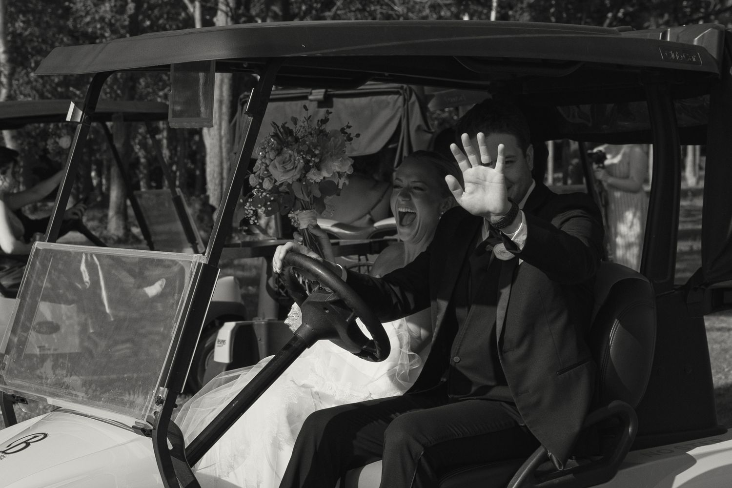 Wedding guests riding in golf carts during an outdoor reception.