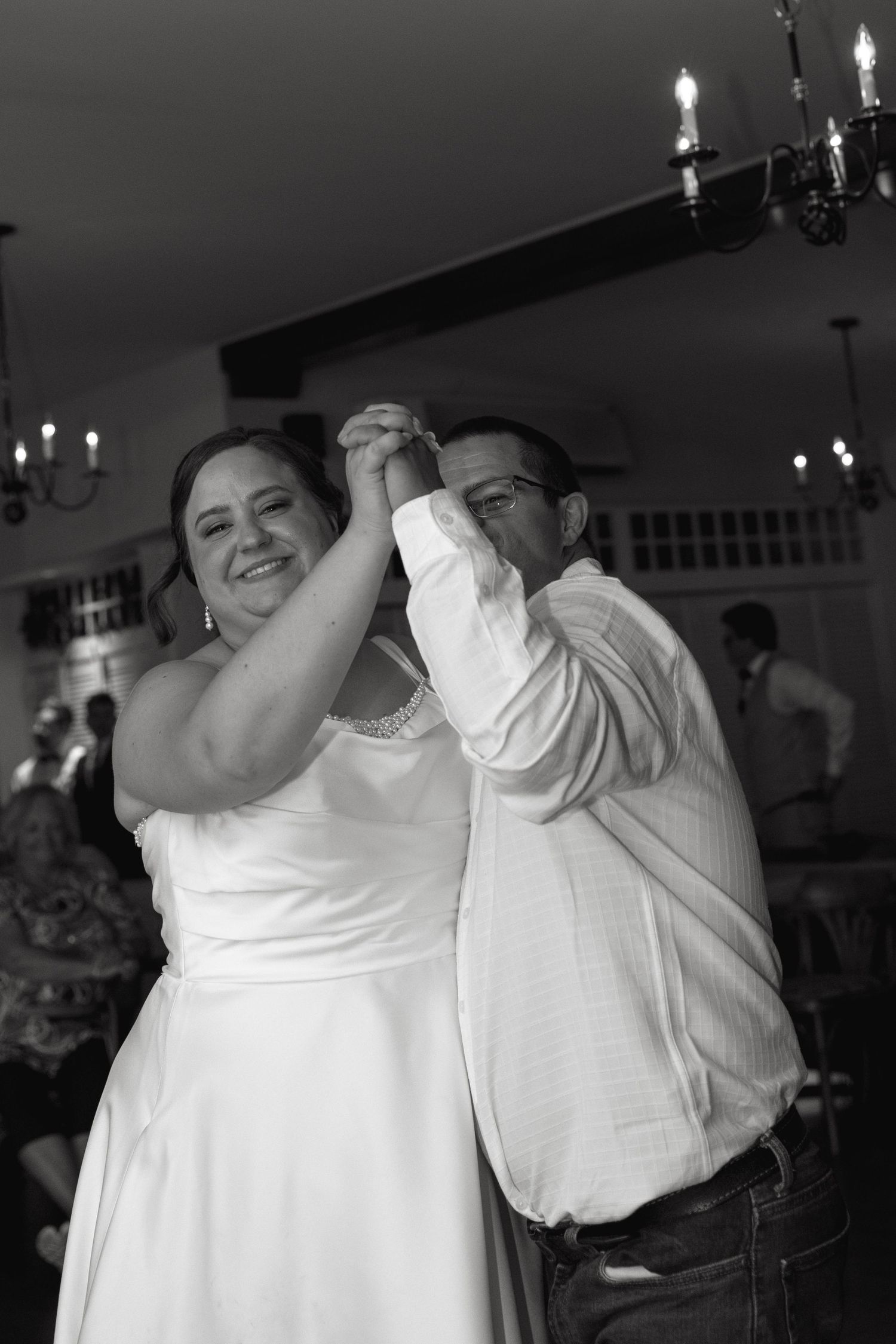 Black and white photo of bride and groom sharing first dance at wedding.