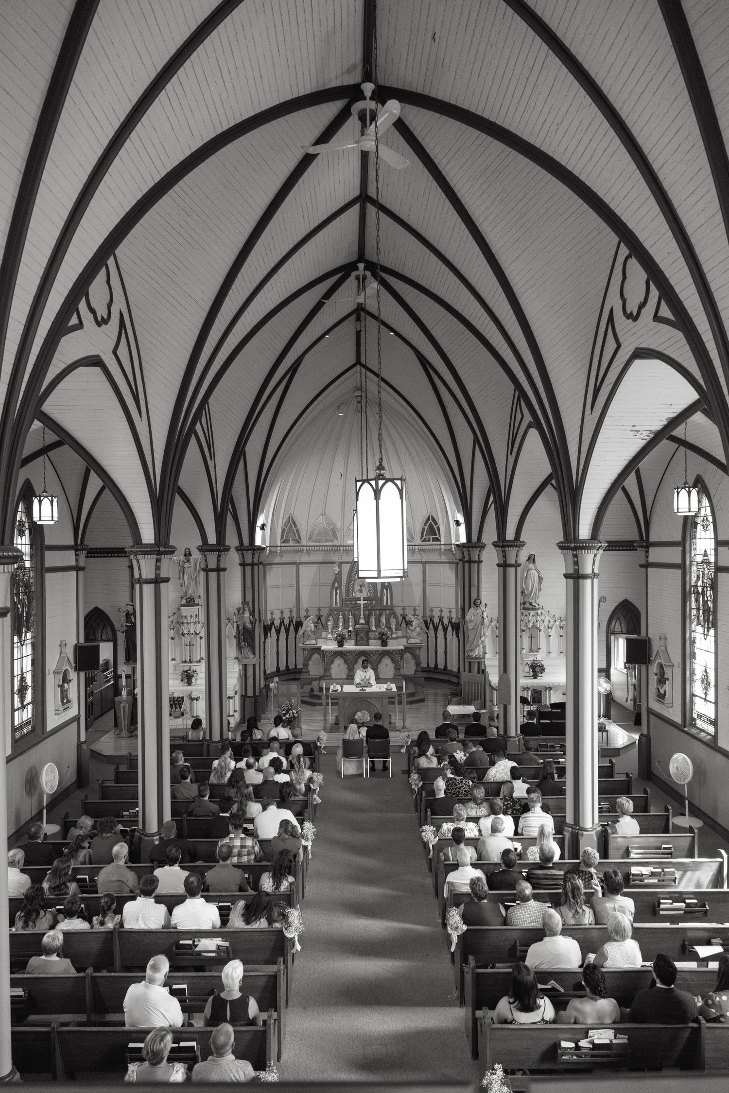 Black and white panorama of a Gothic church interior with vaulted ceilings and arched windows.