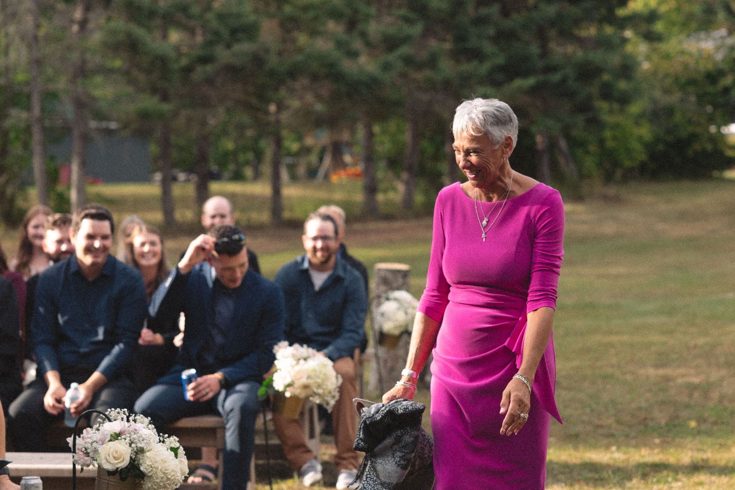 Wedding guests seated in rows during an outdoor ceremony.