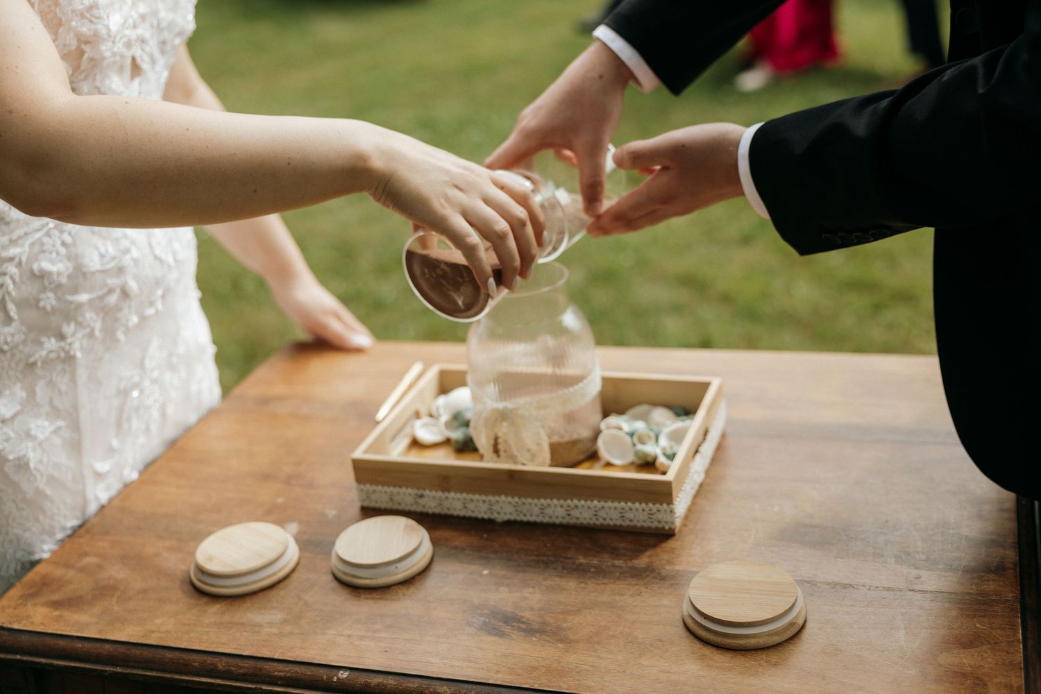 Wedding party participants sharing food from a rustic wooden box outdoors.
