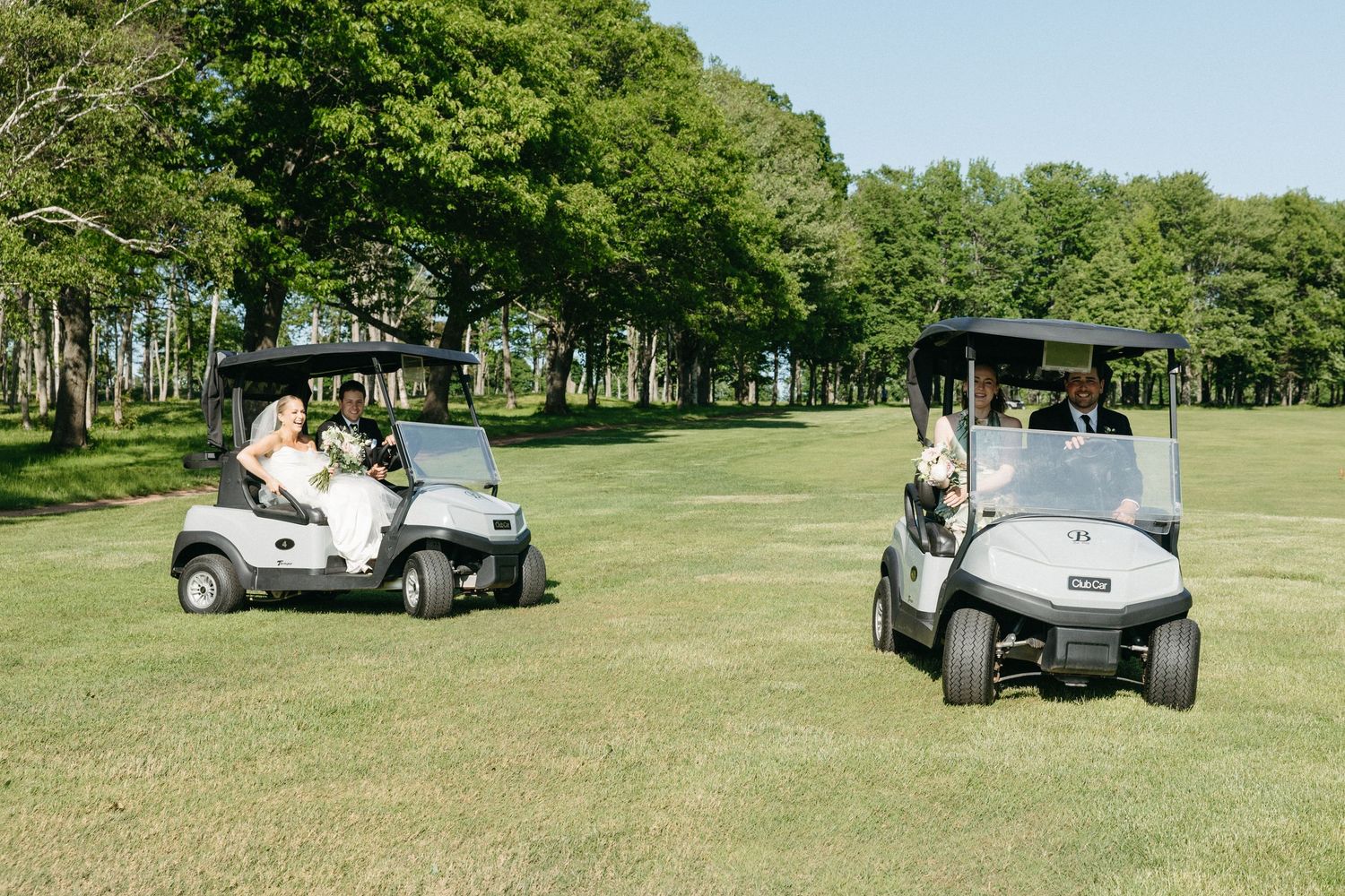 Golf carts carry wedding guests across a sunny golf course.