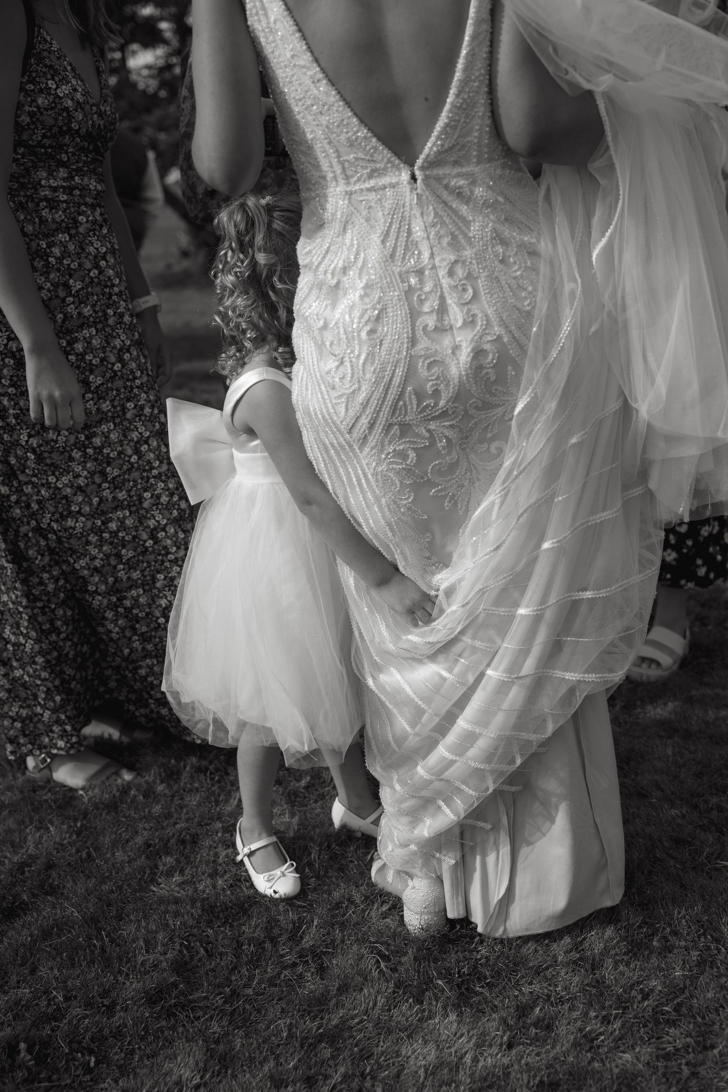 Black and white photo showing details of flowing wedding dress and shoes.