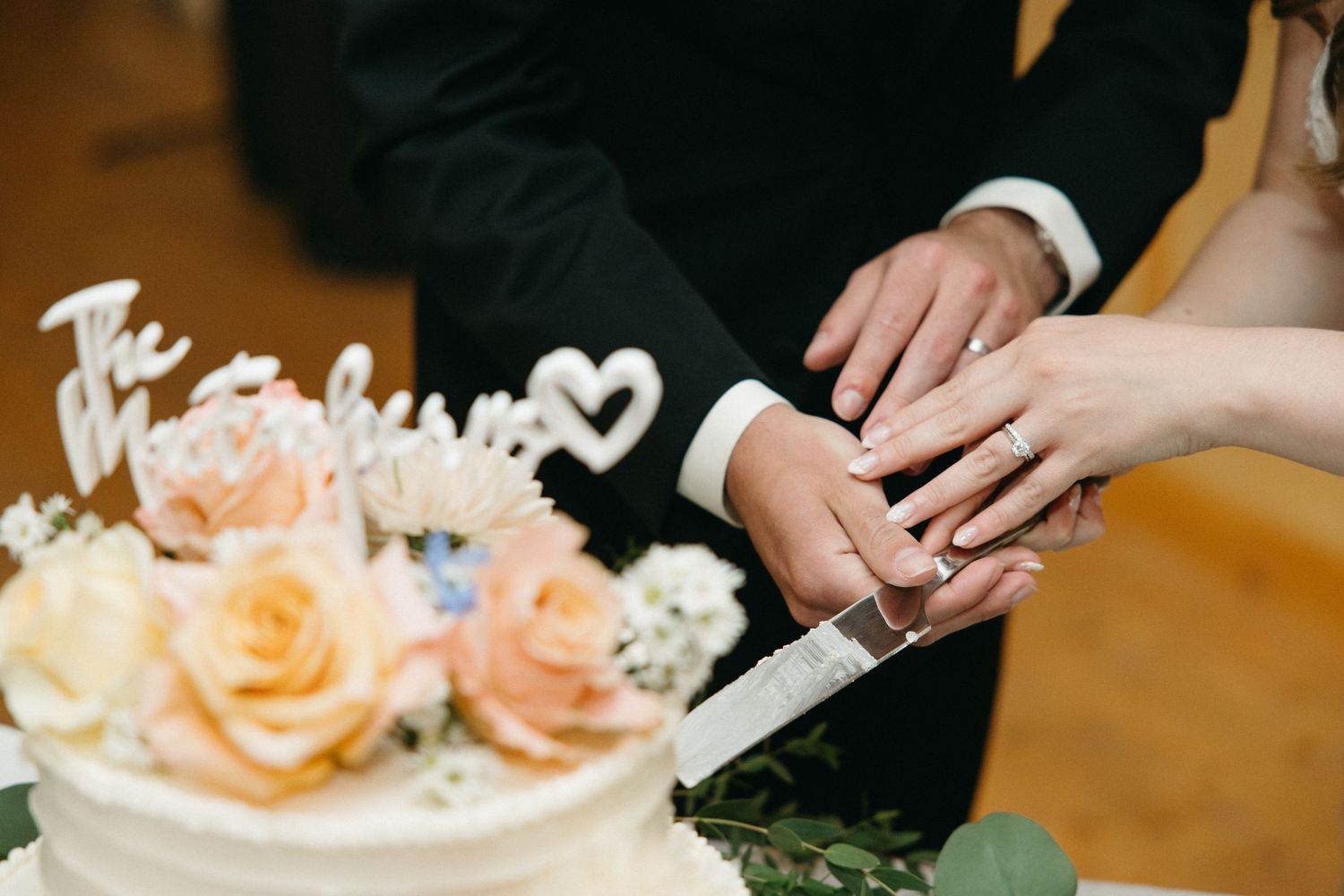 Close-up of wedding cake details with peach-colored floral decorations.