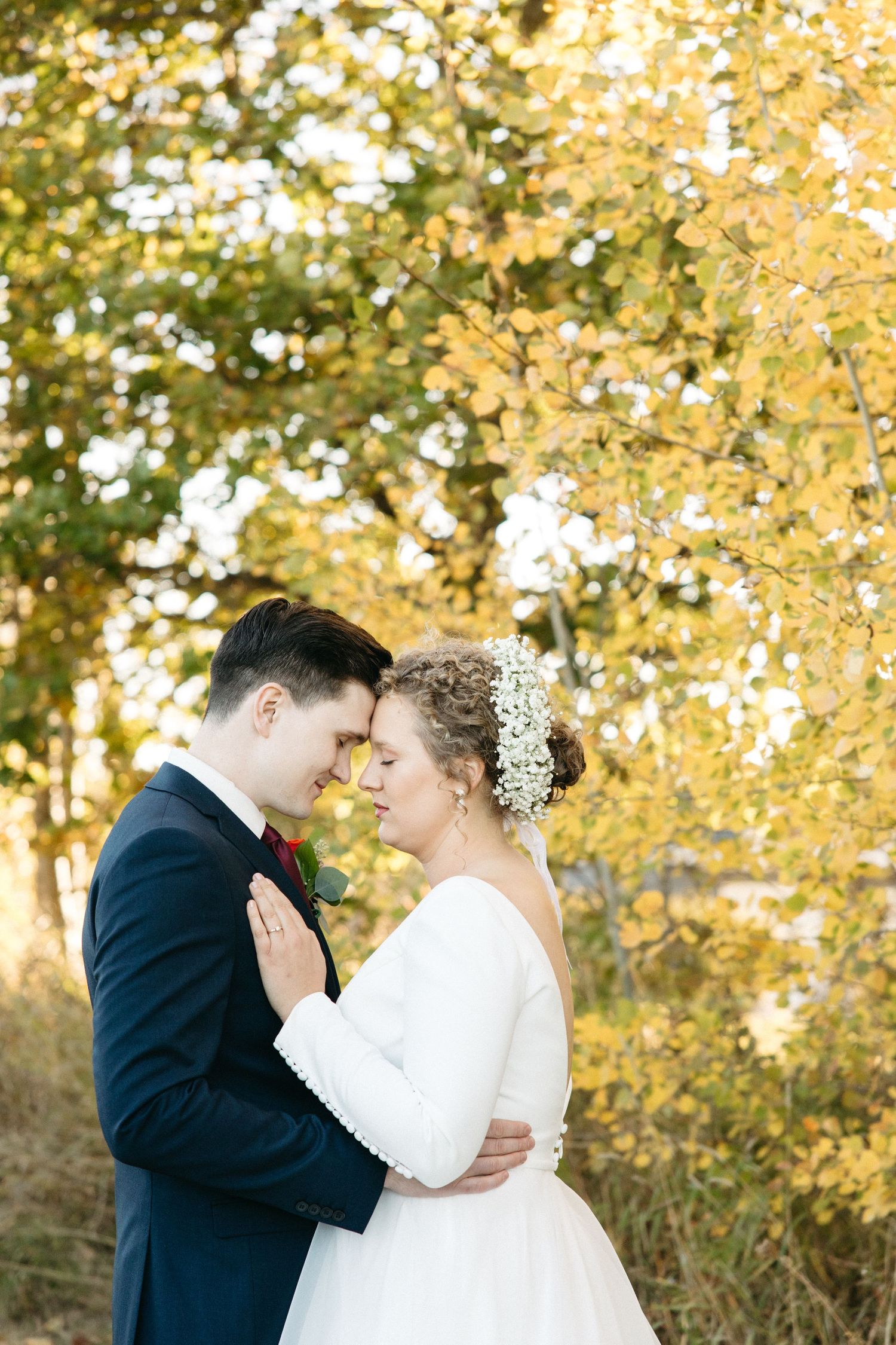A romantic wedding photo shoot with fall colors in the background.