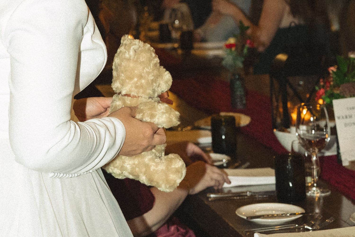 People holding up bread rolls during a dinner celebration.