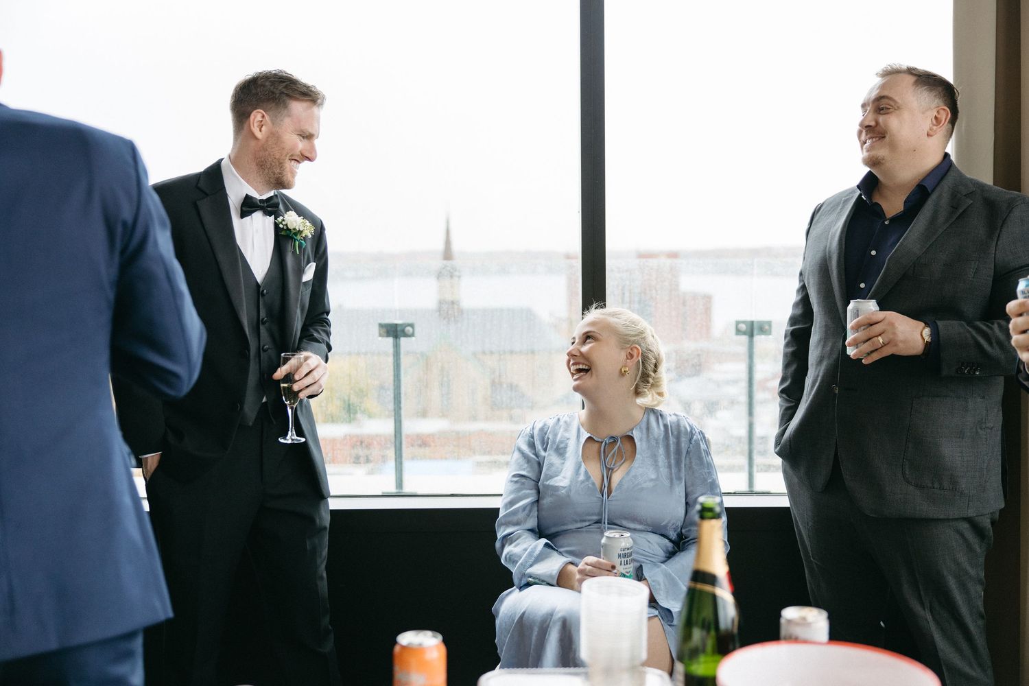 Guests mingling and socializing at an upscale indoor event with city views.