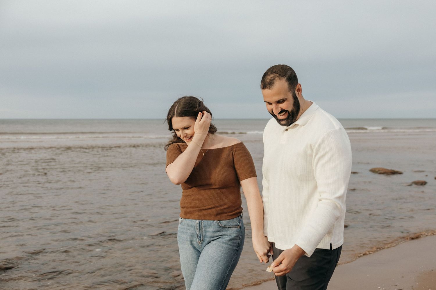 Couple enjoying a romantic moment on a cloudy beach.