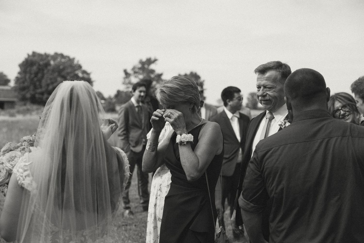 Wedding guests gather outdoors to celebrate during a summer reception.
