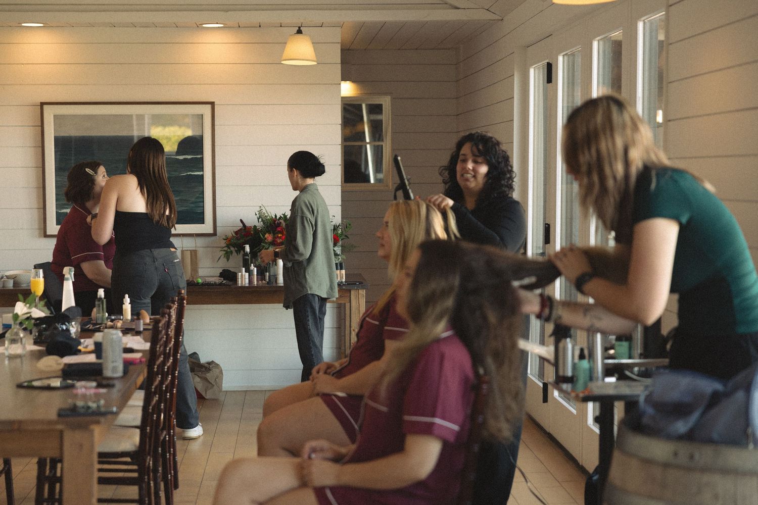 People gathered in a bright white room with shiplap walls for an event.