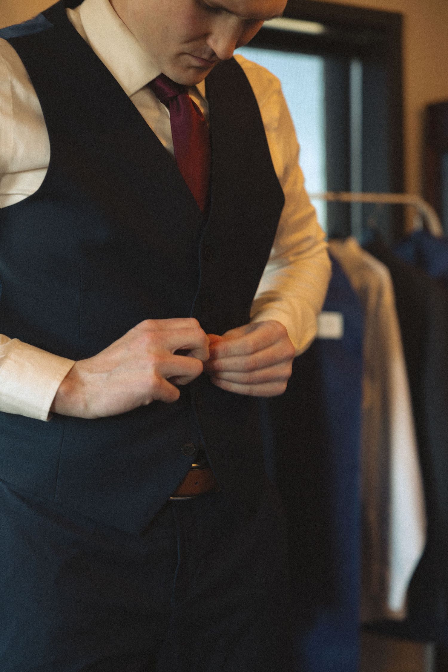 Groomsmen in formal attire prepare for a wedding ceremony.