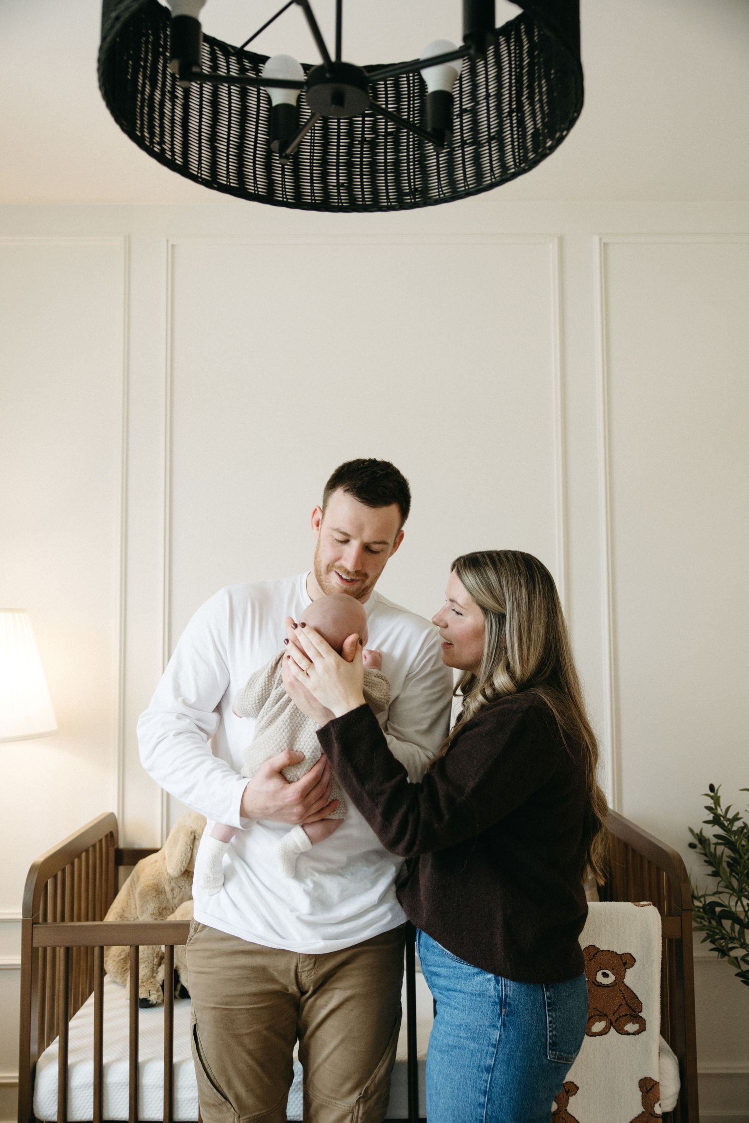 A couple shares playful moments together while sitting on a wooden bench indoors.