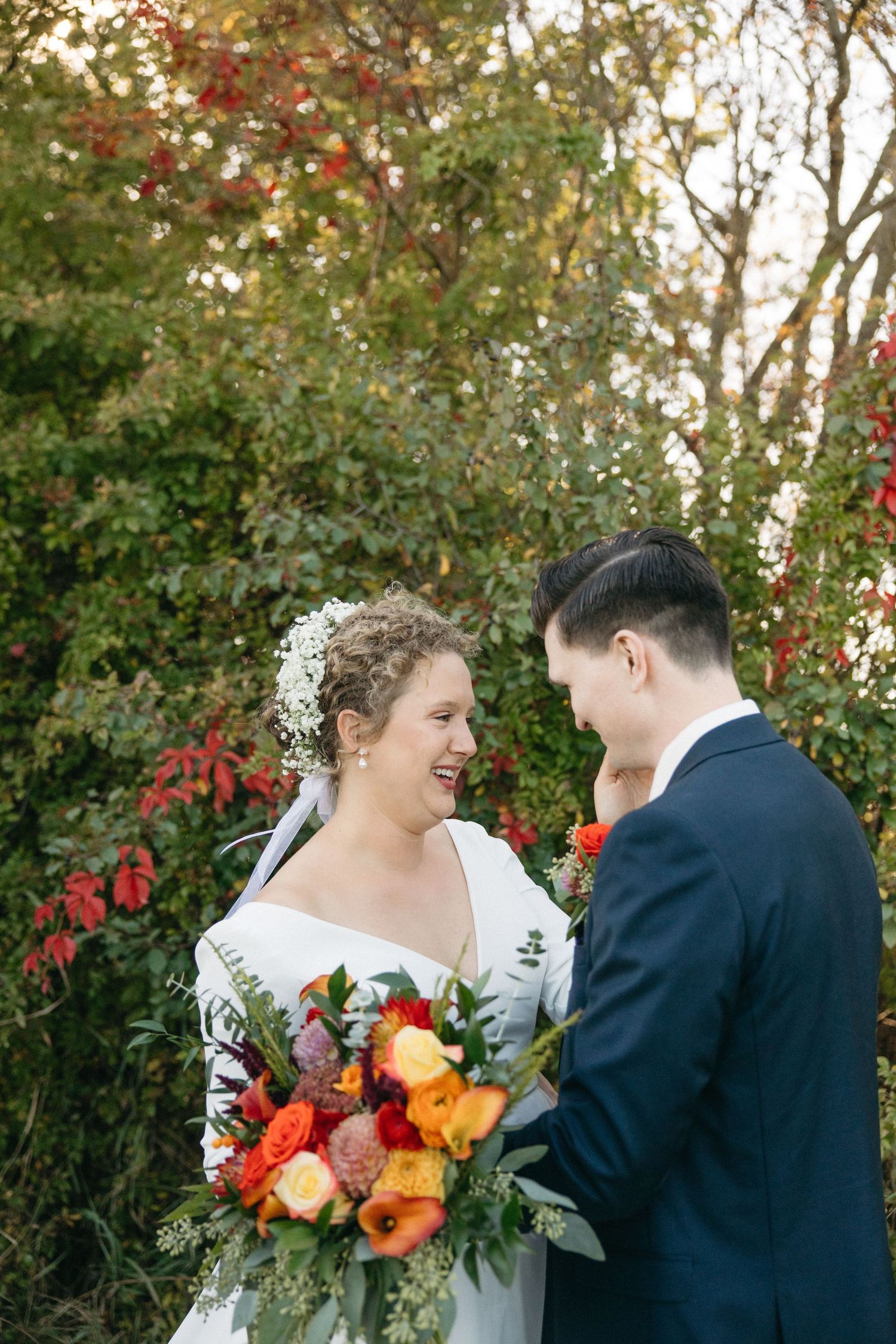 An emotional wedding first look series with autumn foliage and colorful bouquet details.