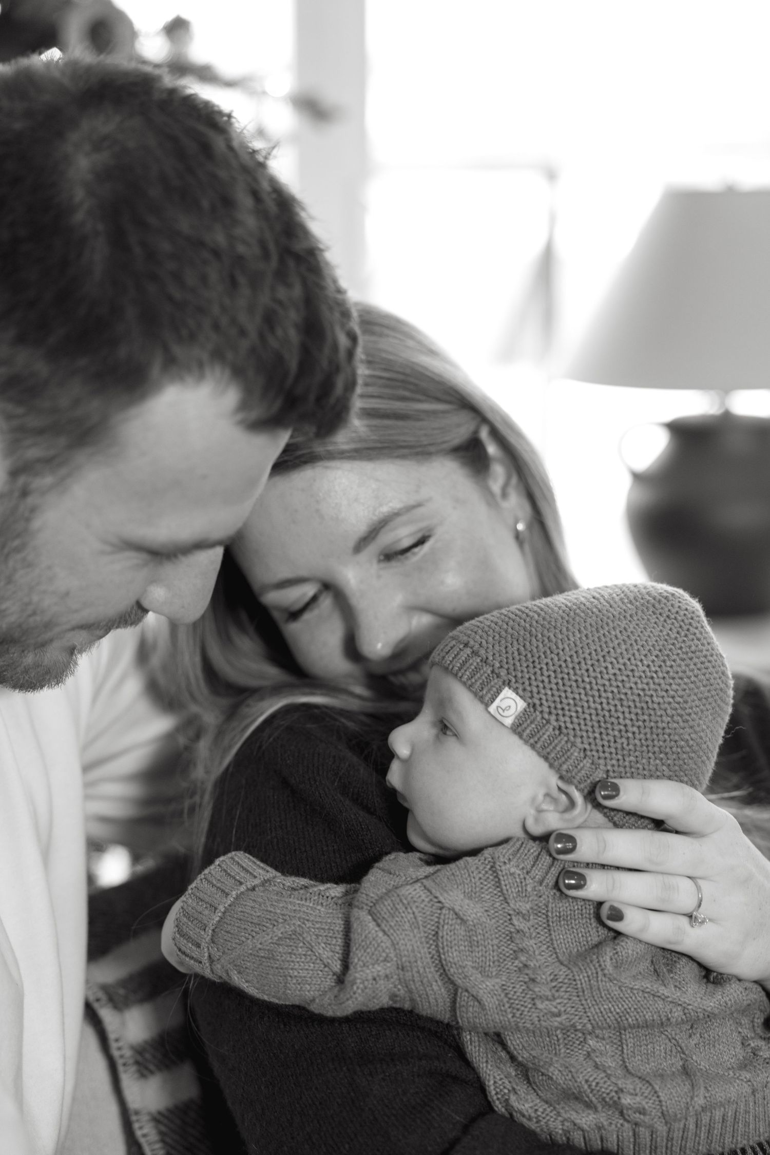 Black and white intimate photos of tender family moments indoors.