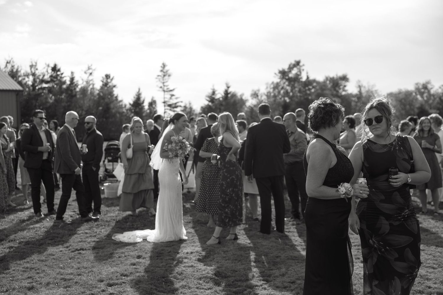 Wedding guests mingling during cocktail hour at an outdoor celebration.