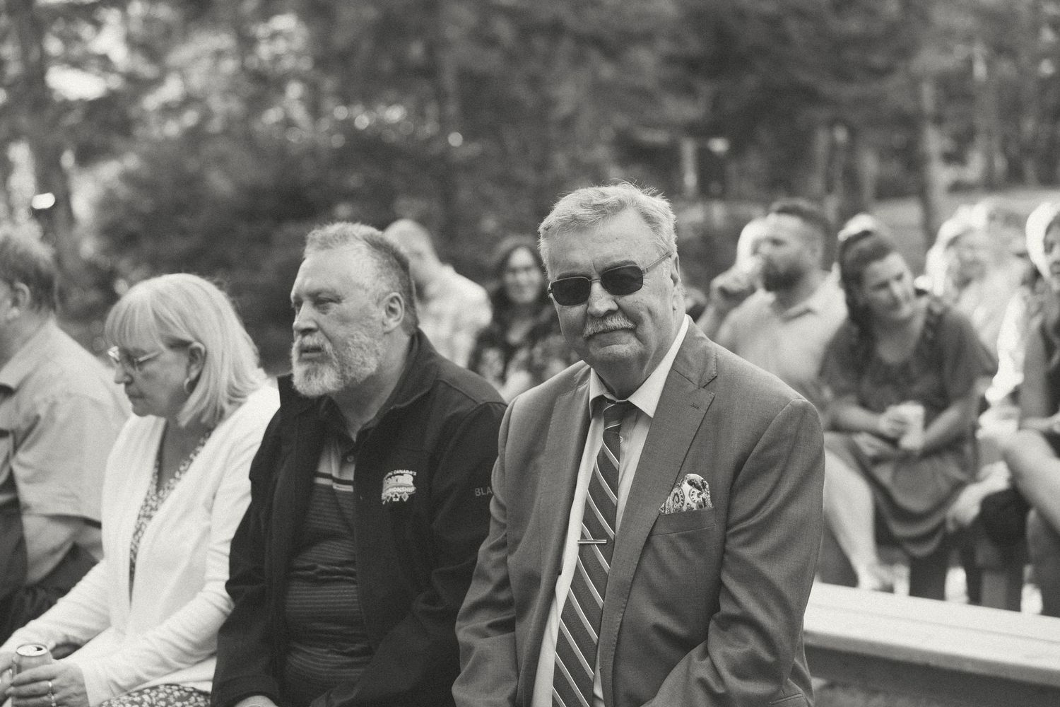 Black and white photo of wedding attendees watching the ceremony.