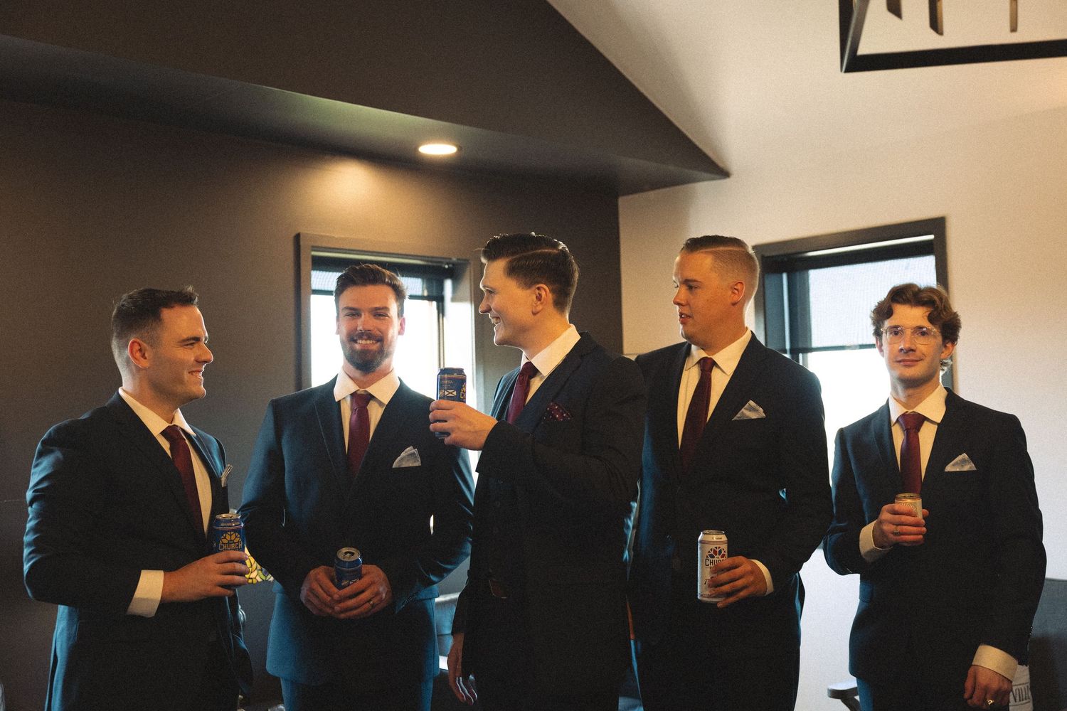 Wedding party members in dark suits gather before the ceremony.