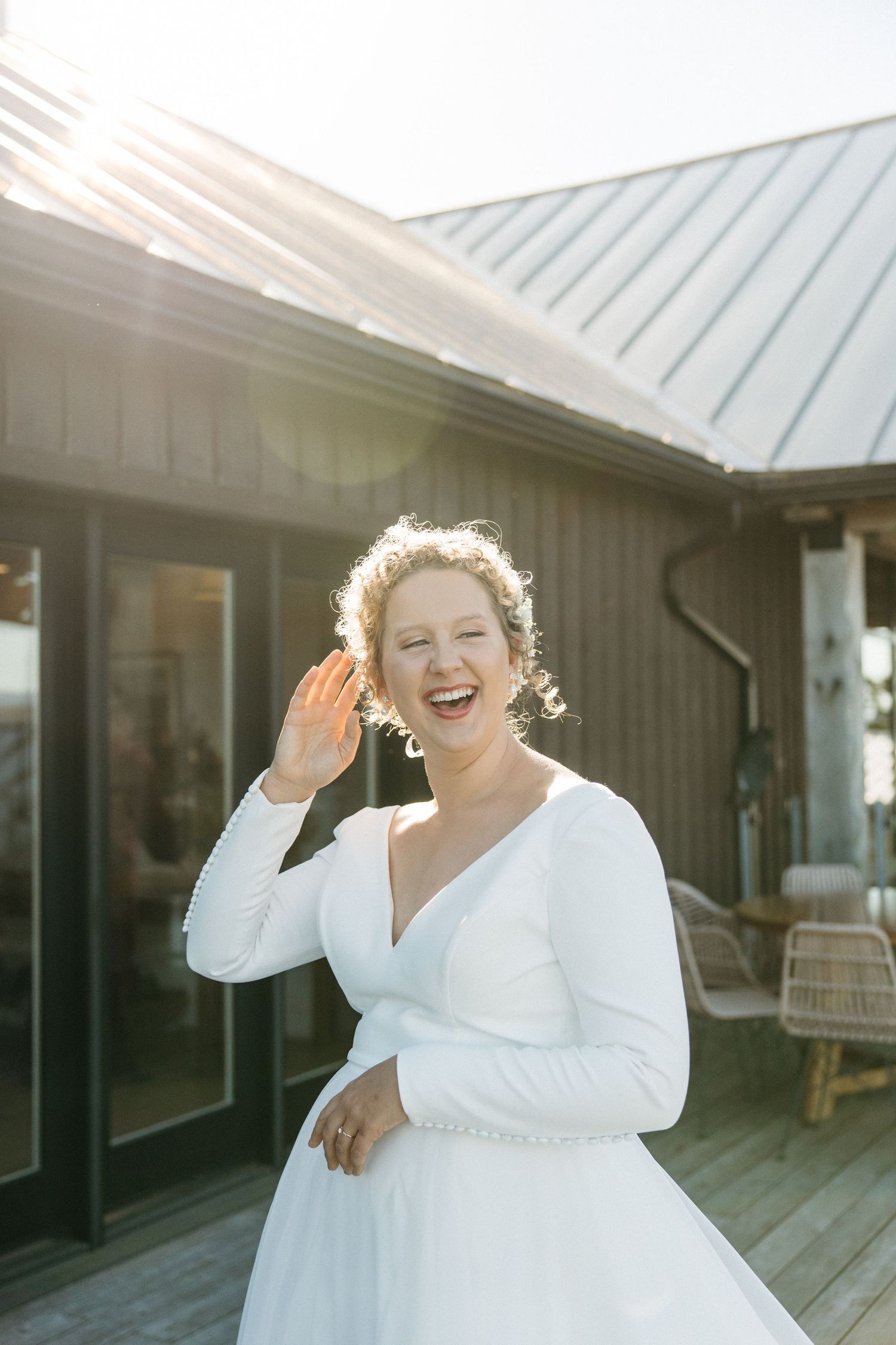 Joyful wedding moments captured in natural sunlight against a modern building exterior.