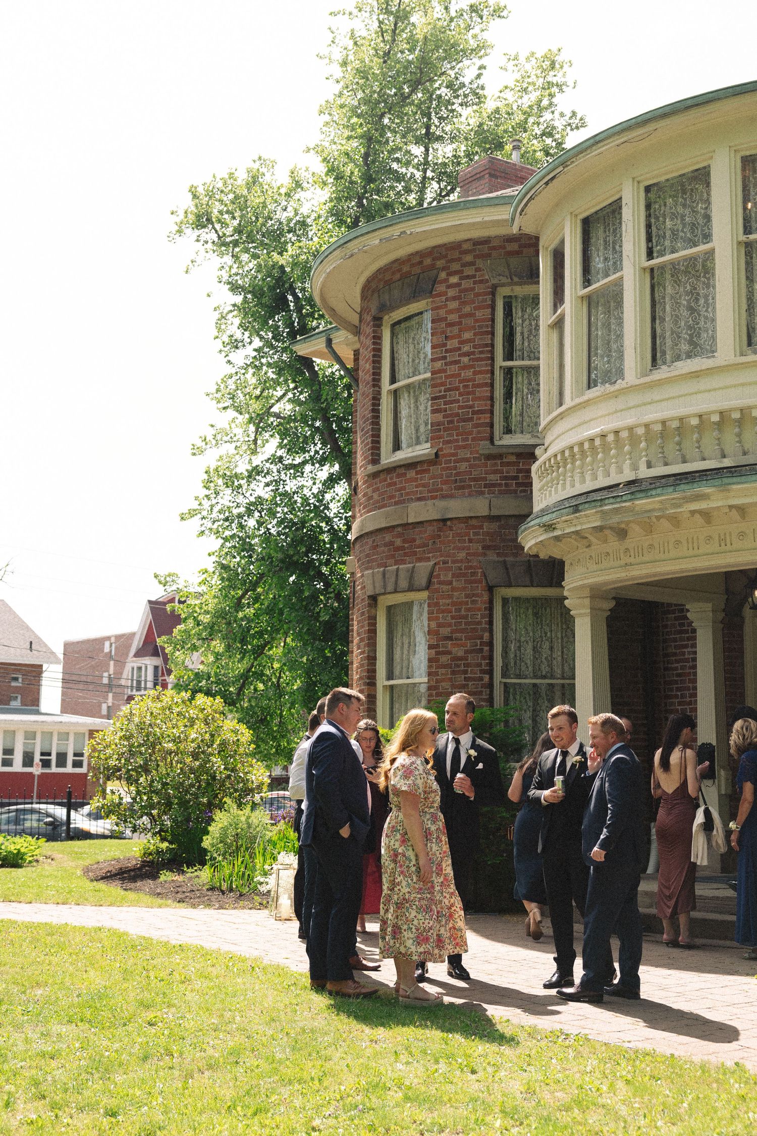 Wedding party gathered outside a historic brick building with columns.